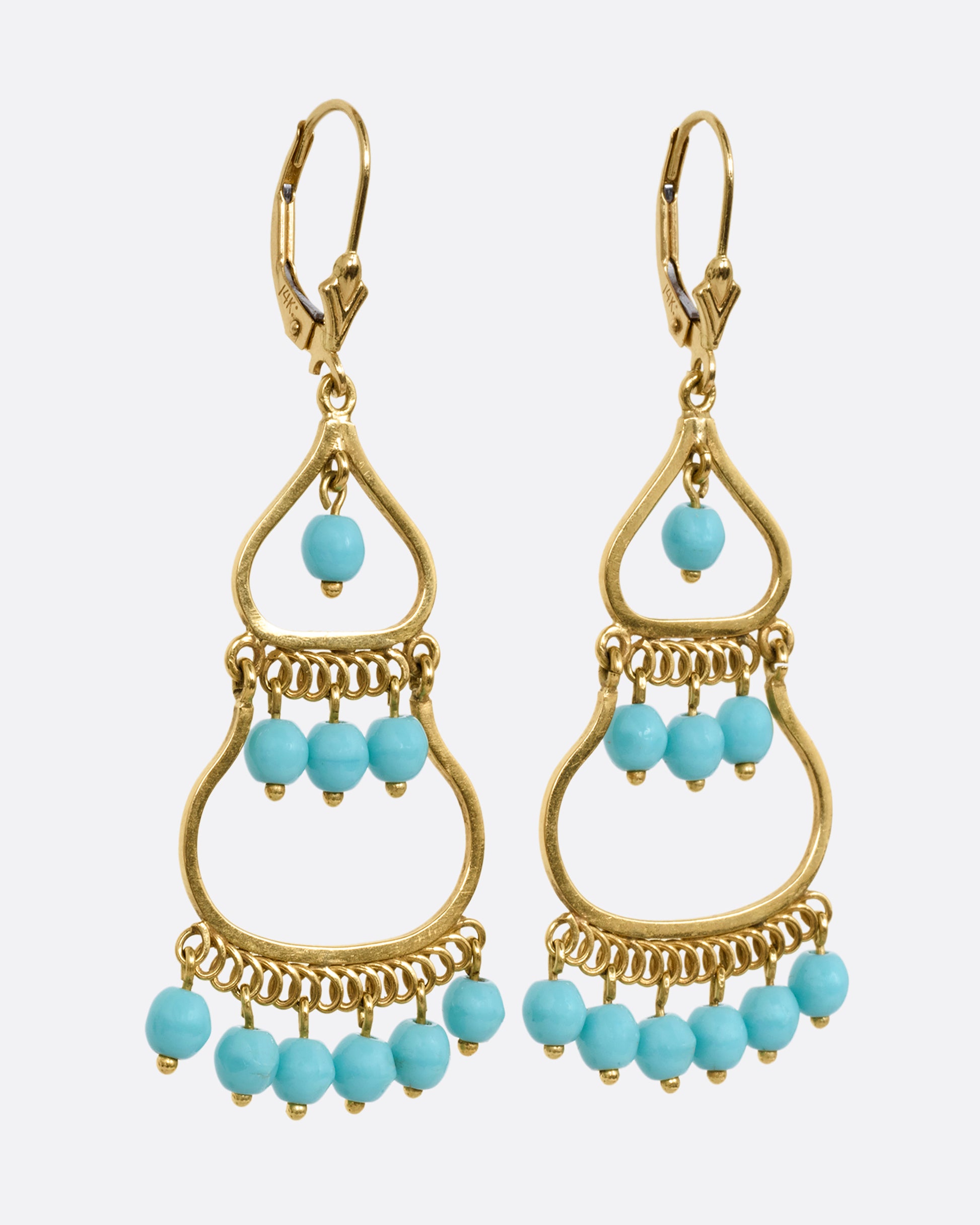 A pair of yellow gold  drop chandelier earrings with turquoise beads, shown from the side.