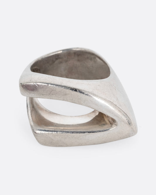 A silver ring with an angular cutout, shown standing up from the front.