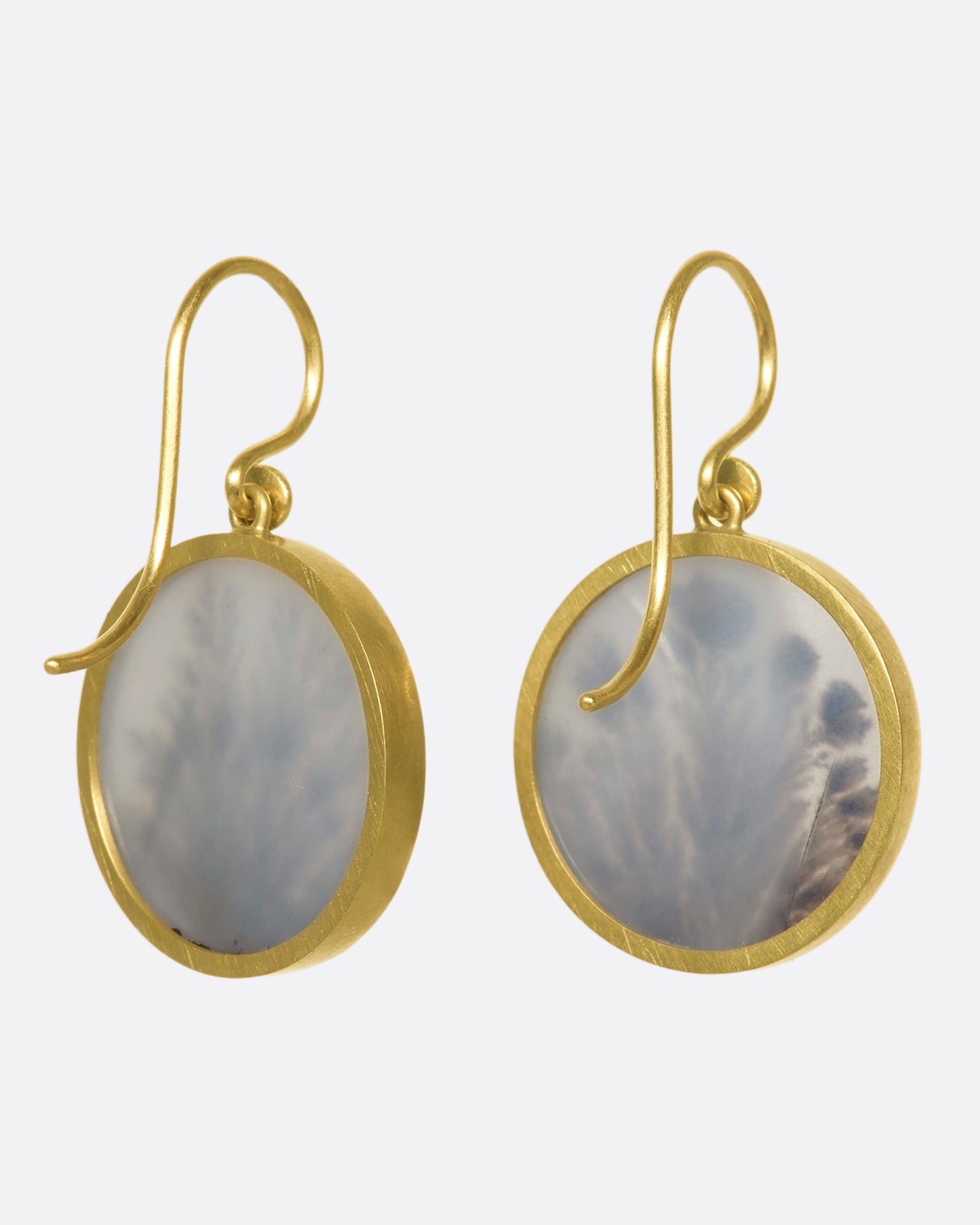 The back of a pair of yellow gold, bezel set, round dendritic agate earrings
