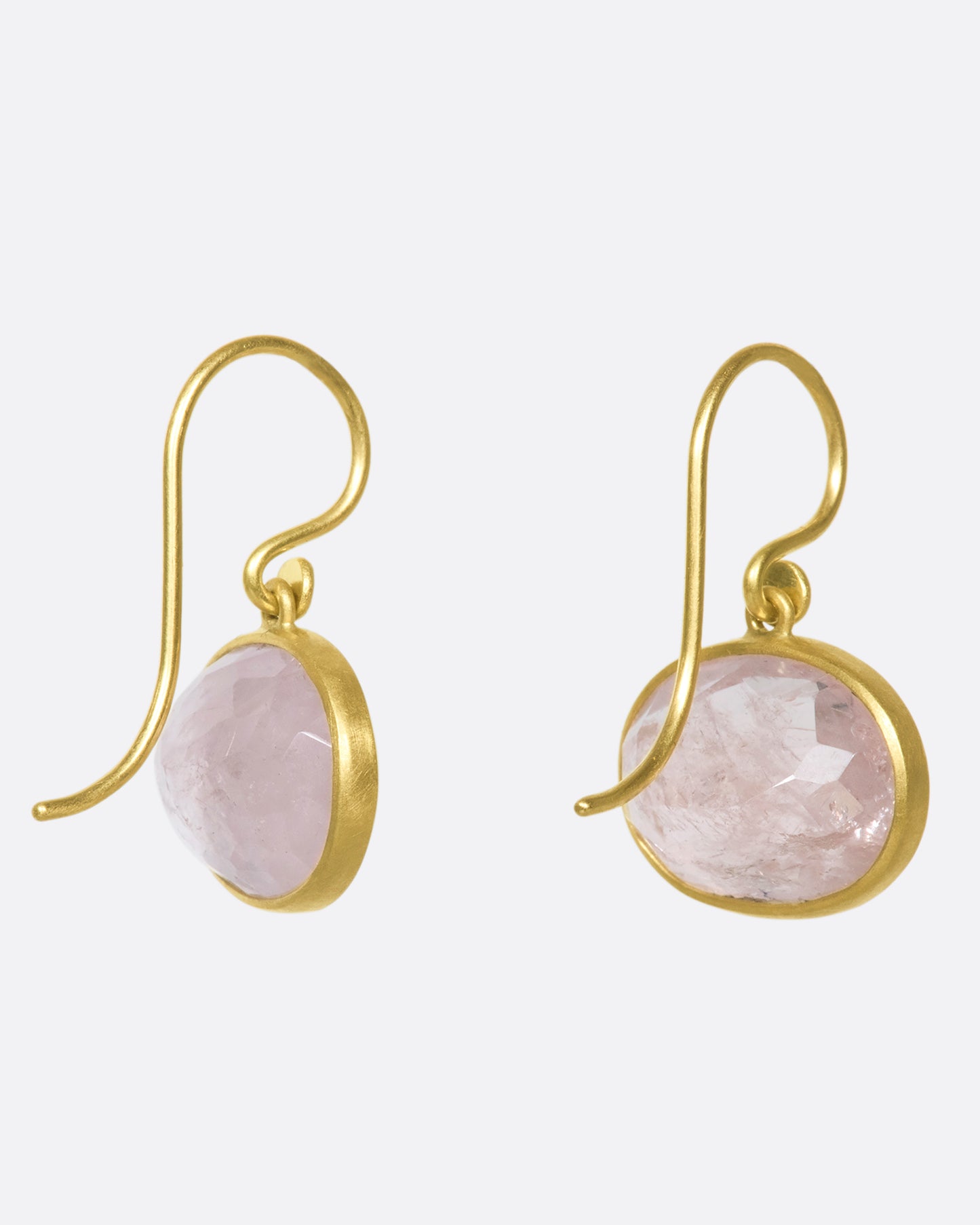 A back view of a pair of oval morganite drop earrings with yellow gold bezels and hooks.