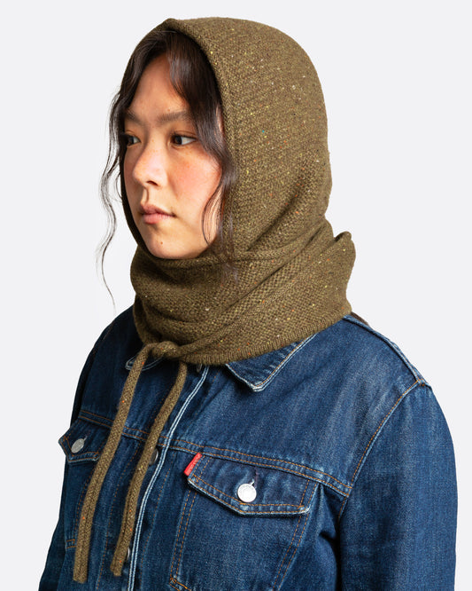 A donegal flecked olive hooded scarf with elongated sides, shown wrapped on a person.