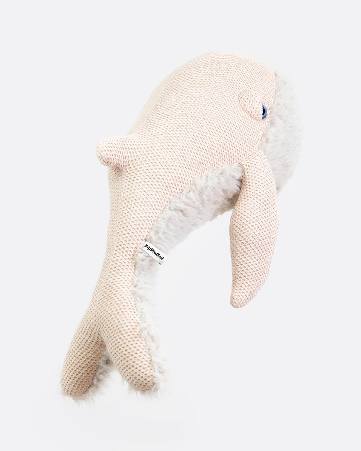 Pale pink knit stuffed whale from the back.