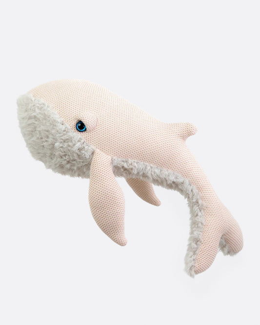 Large pale pink knit stuffed whale with a fluffy cream belly shown from the side.