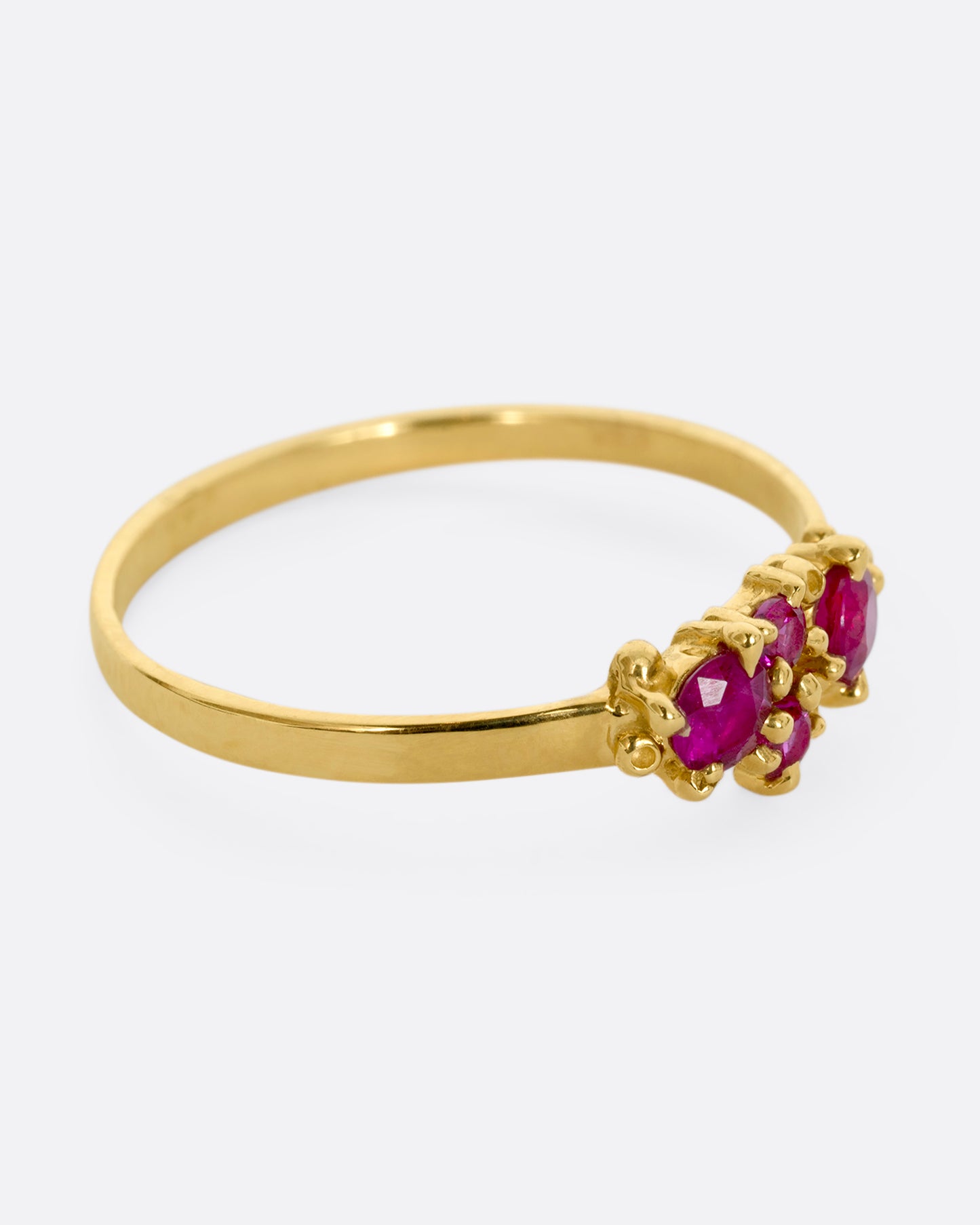 A yellow gold ring with a cluster of four rubies. Shown from the alternate side.