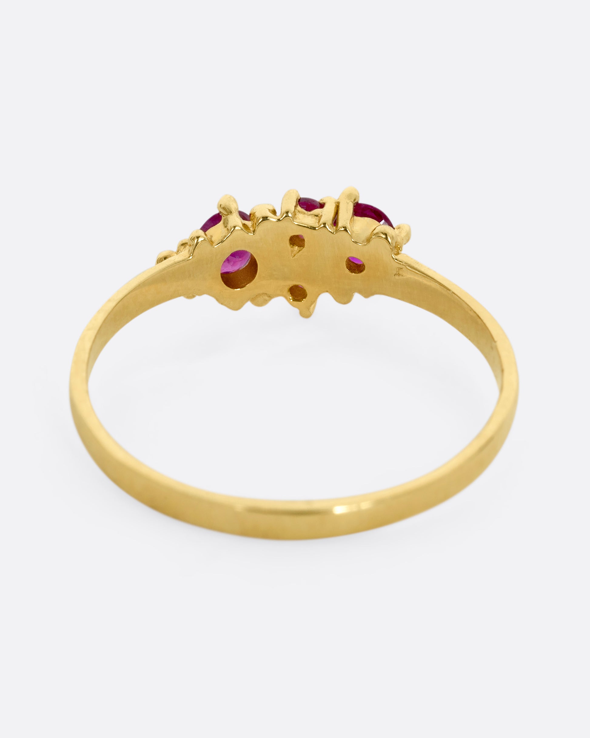 A yellow gold ring with a cluster of four rubies. Shown from the back.