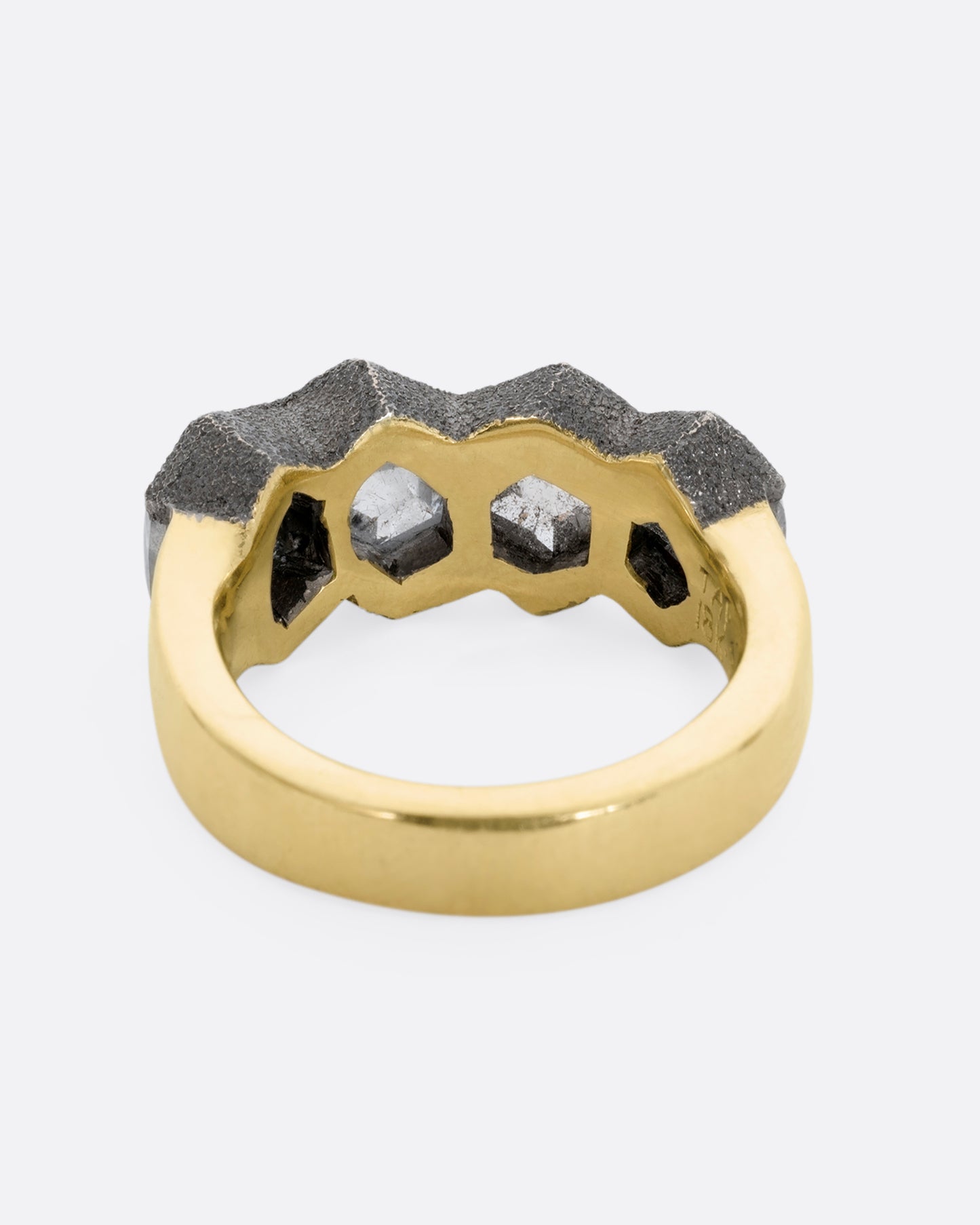 A yellow gold band featuring four hexagon shaped rose cut diamonds. View from the back.