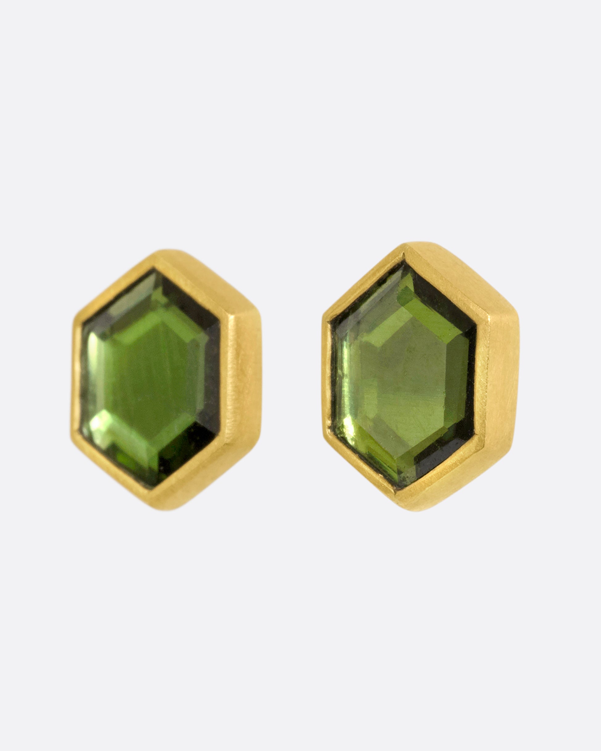 Yellow gold hexagon studs with bezel set green chrome tourmaline. View from the side.