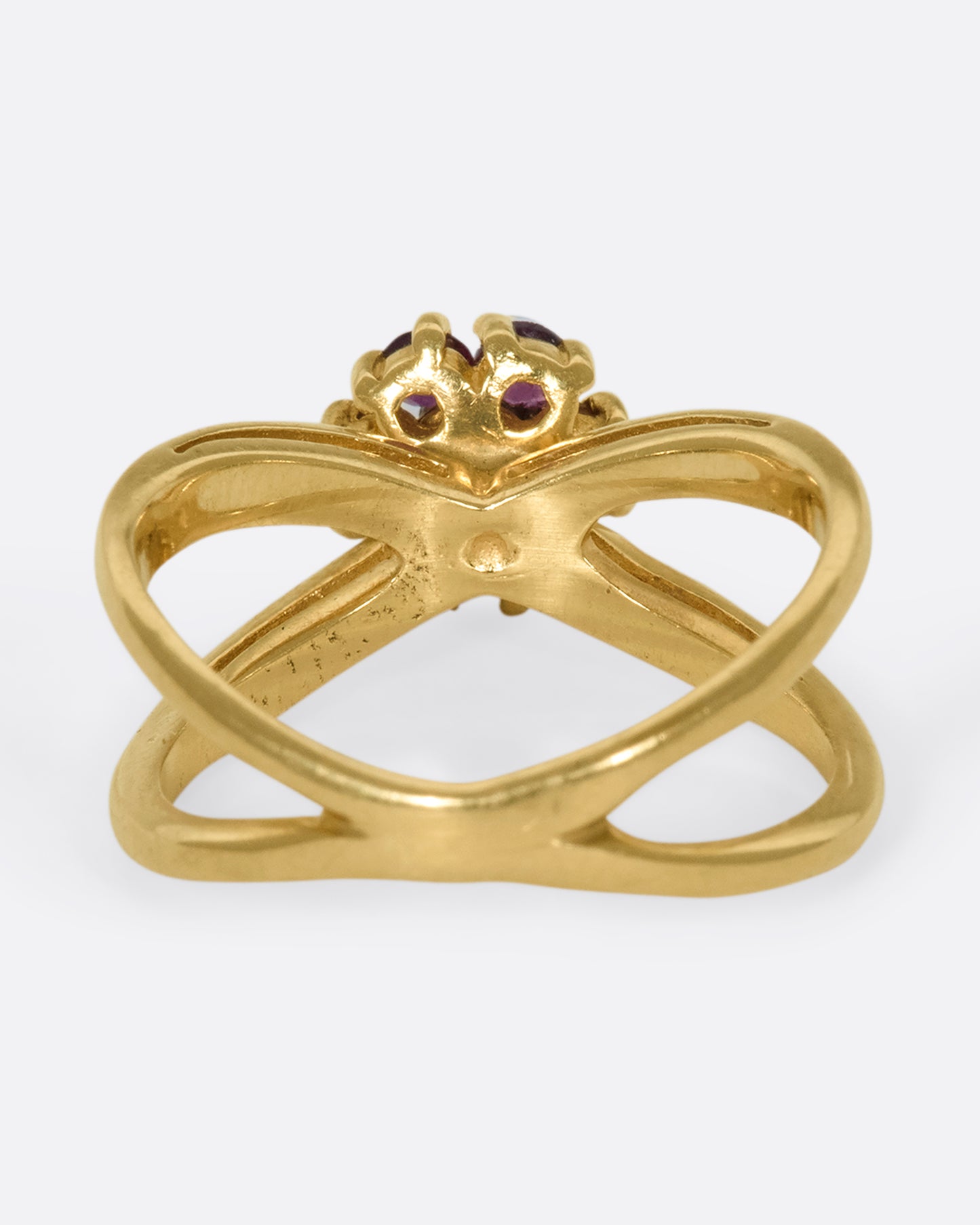 A view of the underside of a yellow gold double banded ring with a ruby and diamond flower in the center.