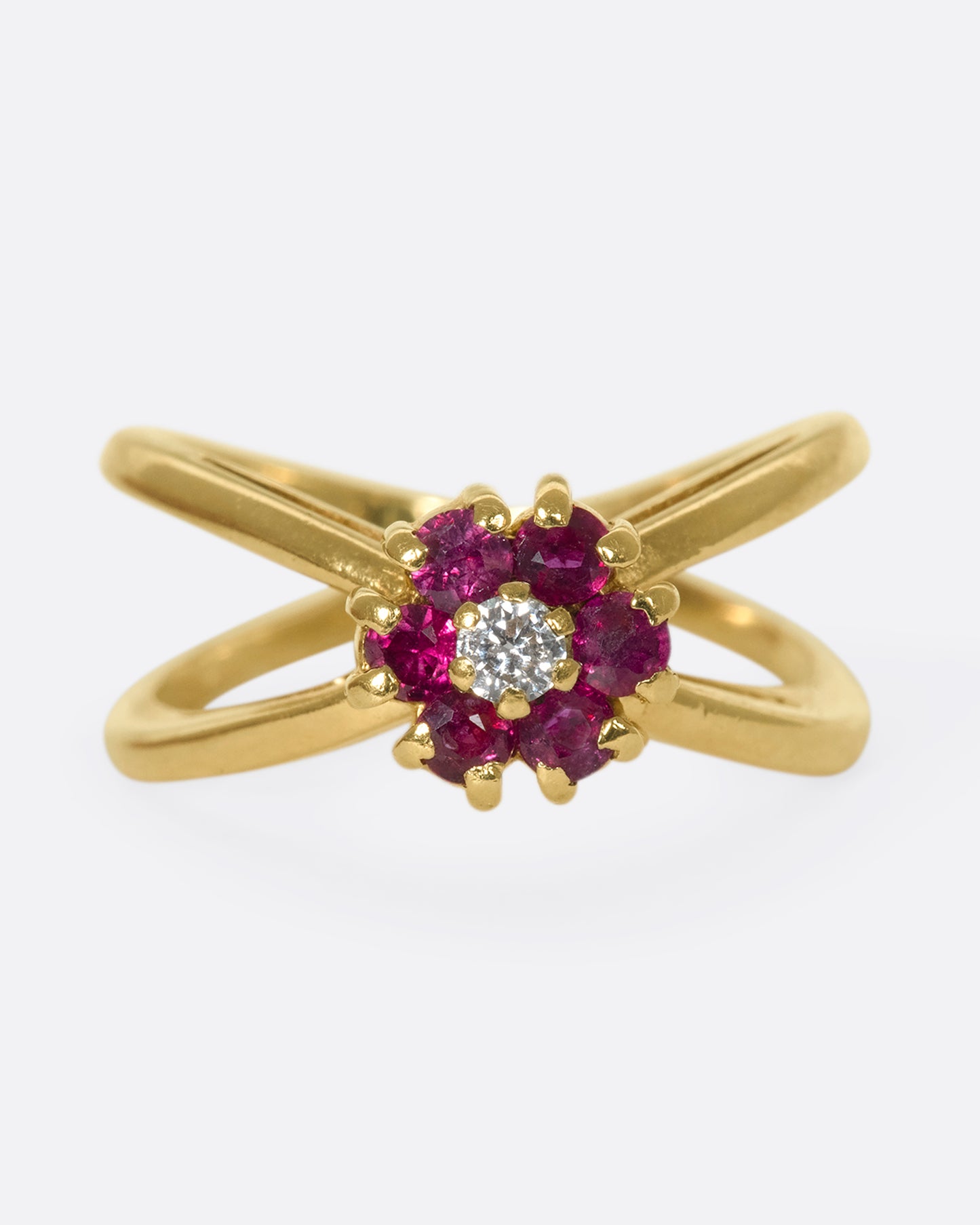 A forward view of a yellow gold double banded ring with a ruby and diamond flower in the center.