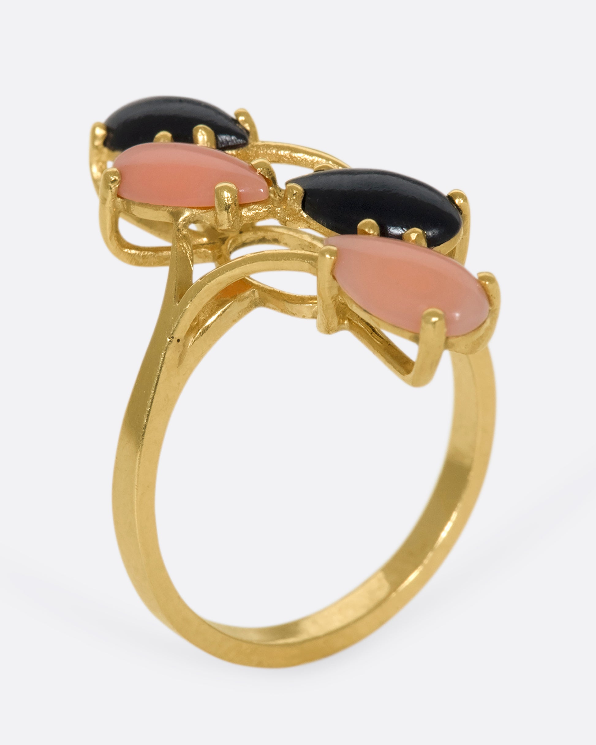 This vintage 14k gold ring features pear shaped coral and onyx cabochons that climb and elongate your finger.