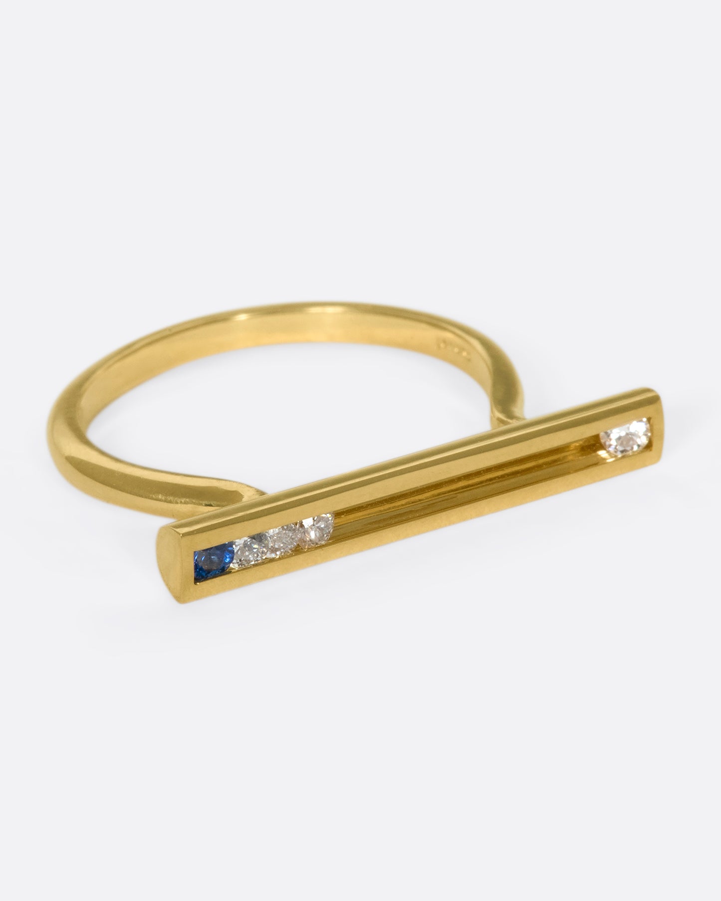 A flat-face ring with blue sapphires and diamonds that glide across an 18K gold bar.