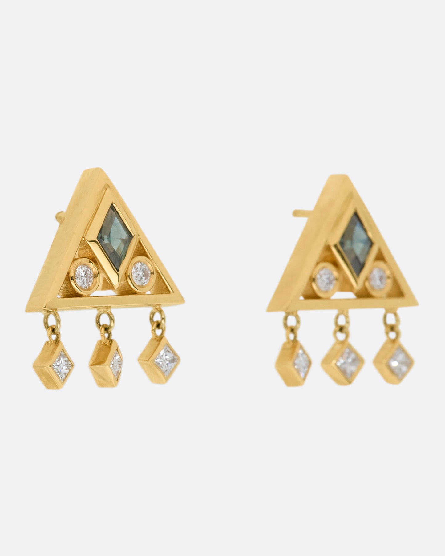 A gorgeously geometric pair of 14k gold triangle studs with teal sapphire lozenges and diamond accents