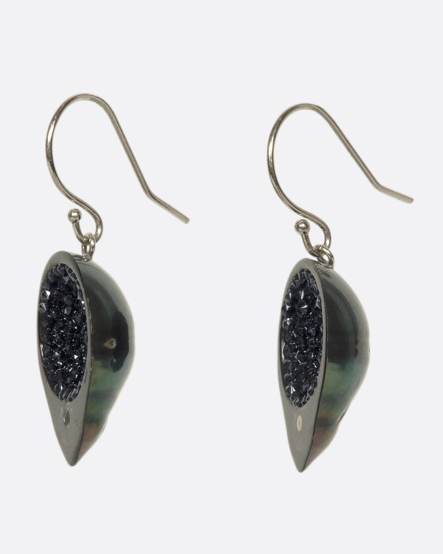 A stunning pair of Tahitian baroque pearls with 14k white gold hooks. The black pearl with green and purple iridescence are lined with reclaimed black diamonds and full of wicked sparkle.