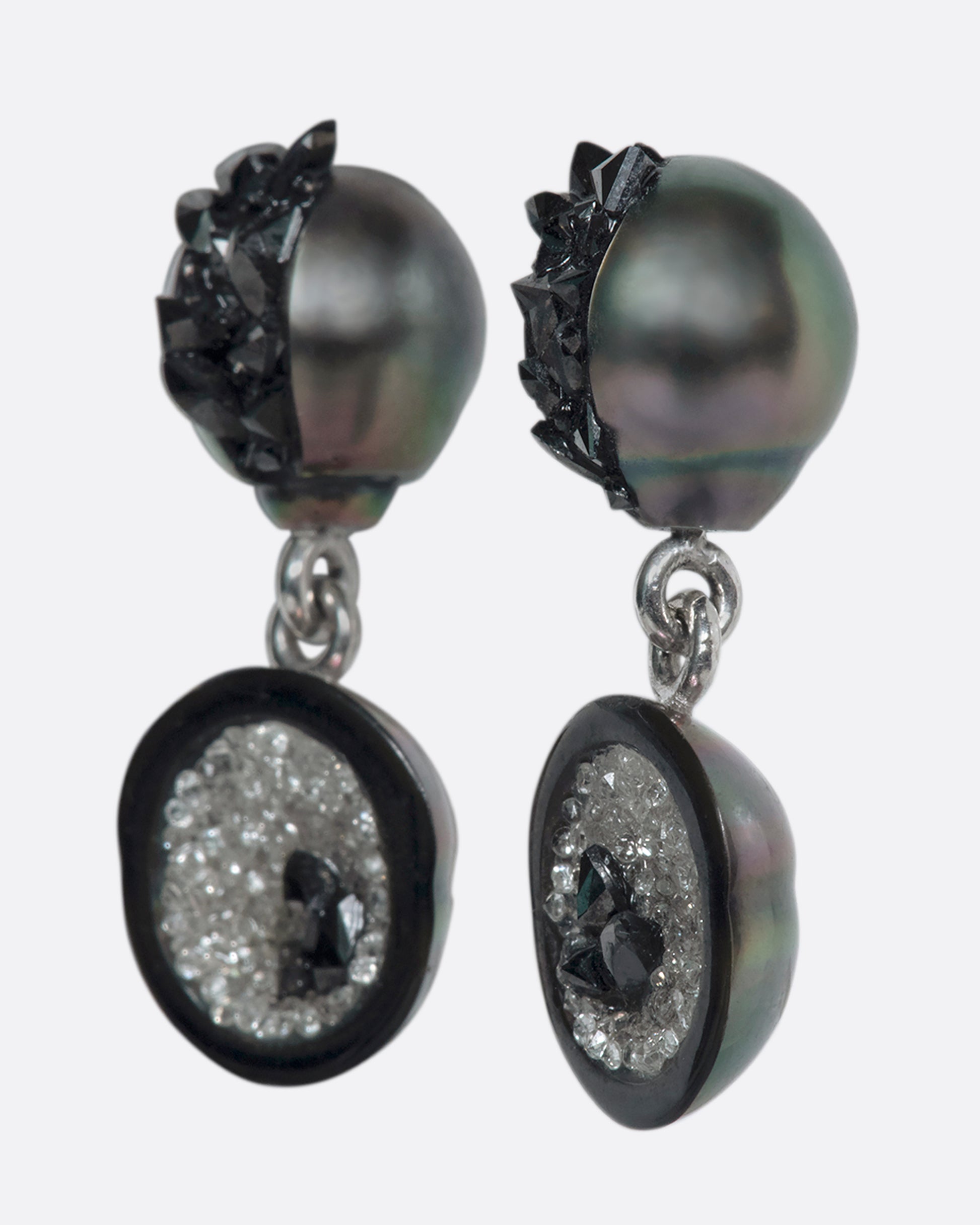 Double-drop Tahitian pearl earrings with 14k white gold posts. The top pearls are bursting with spiky black diamond shards, while the bottom pearls are delicately lined with tiny white and black diamonds.