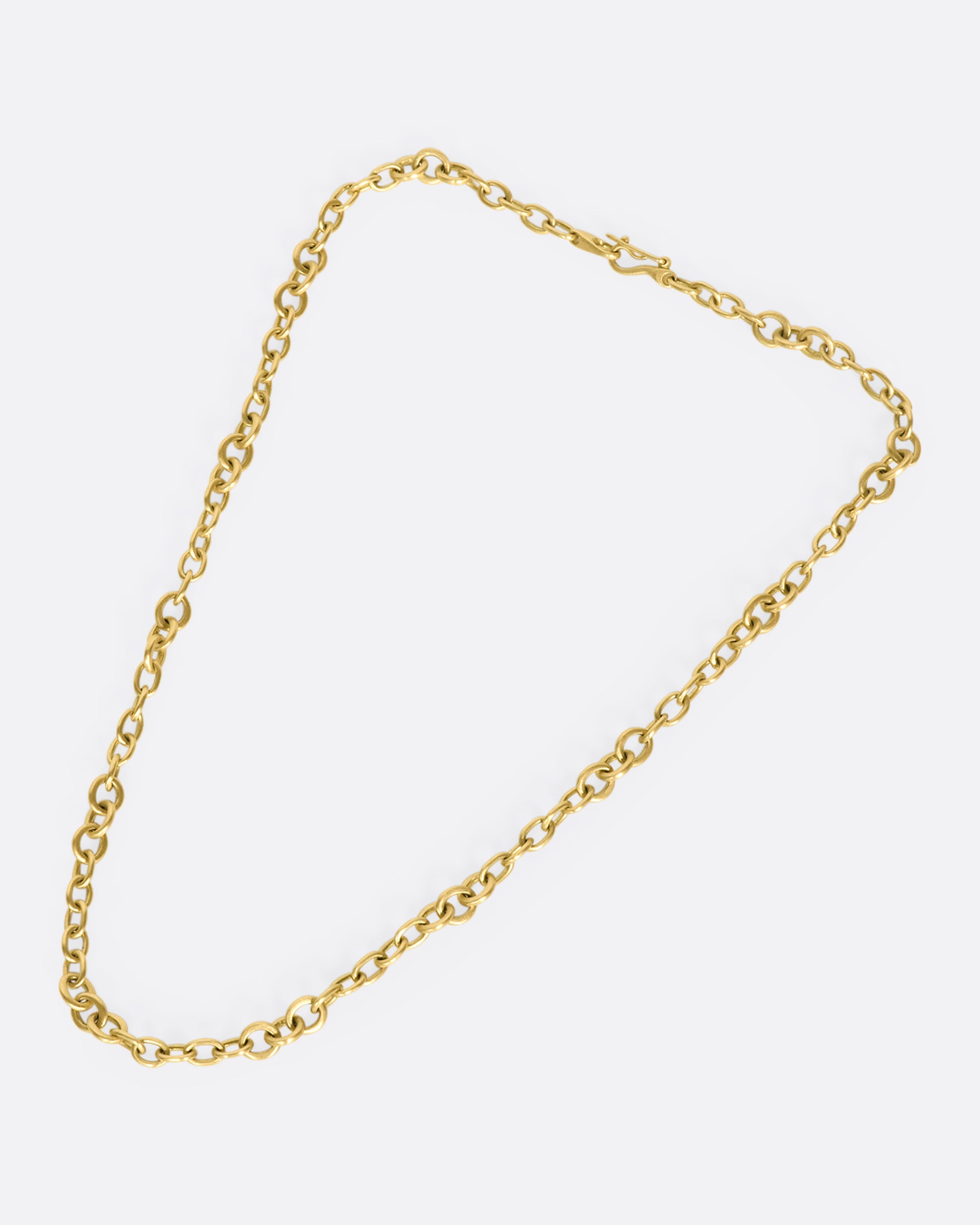 A beautiful 18K gold chain that will rest along your collar bone. Heavy enough to wear on its own in a neck mess and fine enough to add a pendant or two.