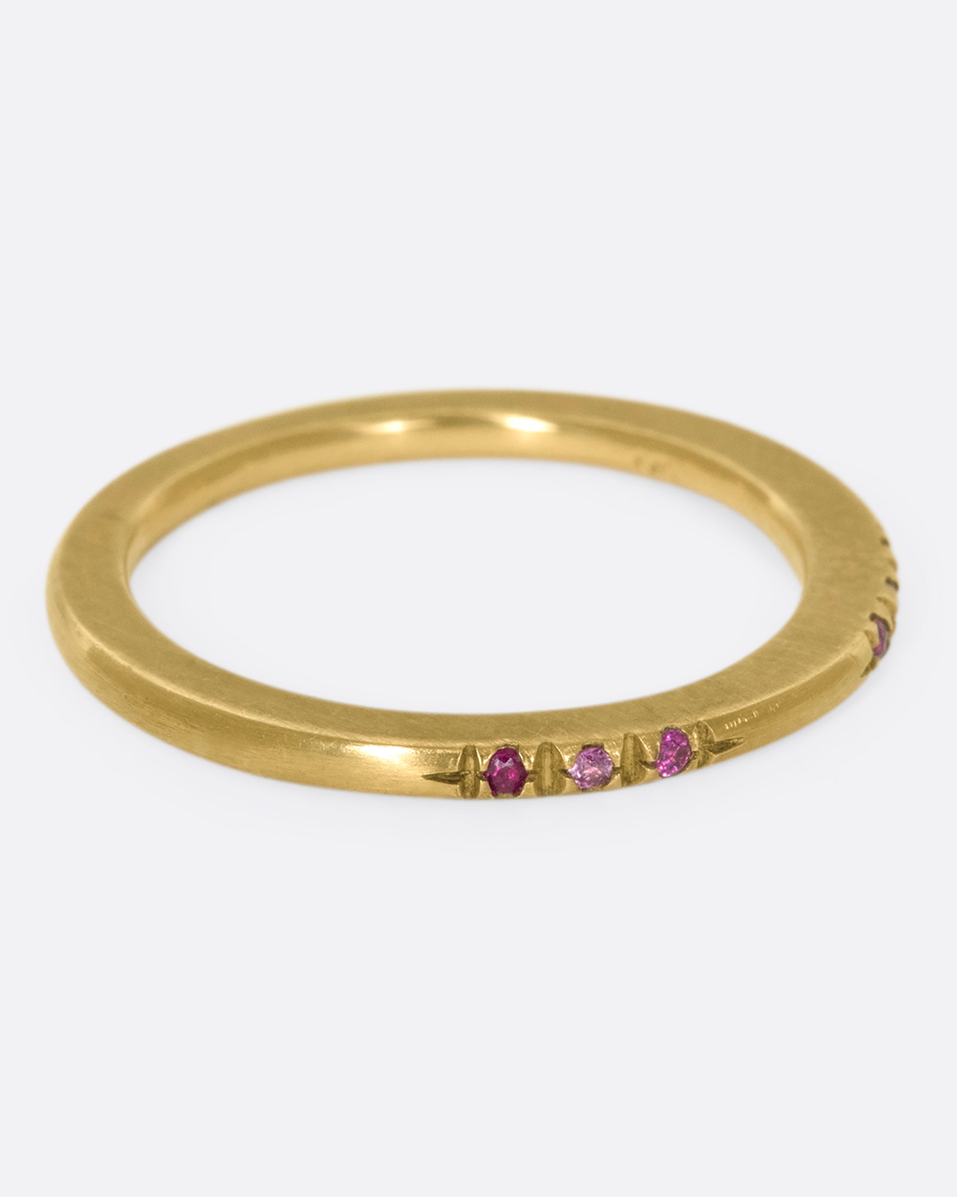 A 10k brushed gold band with rubies and pink sapphires