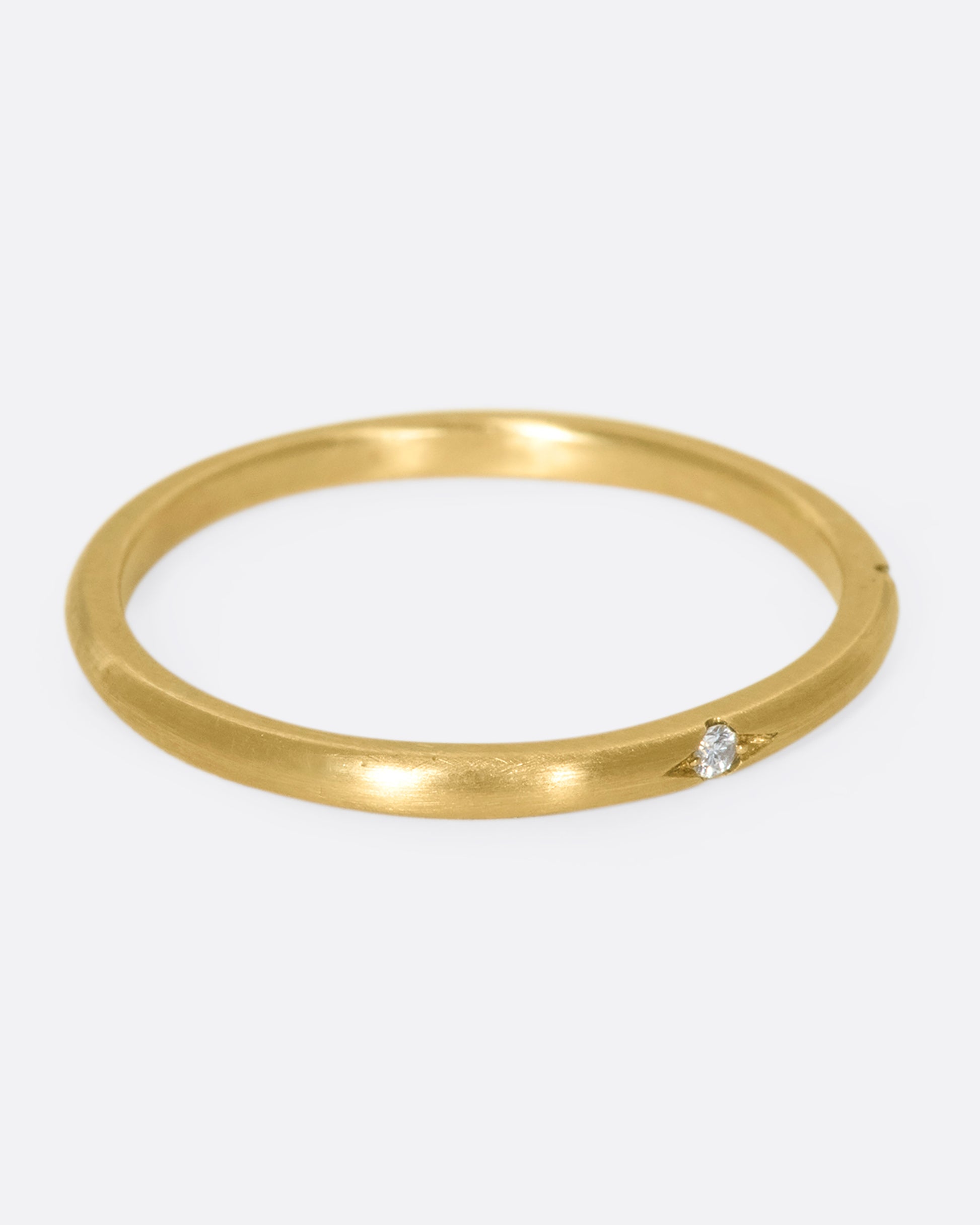 This 10k gold stacking ring features two flush-set white diamonds that sink into the soft gold band