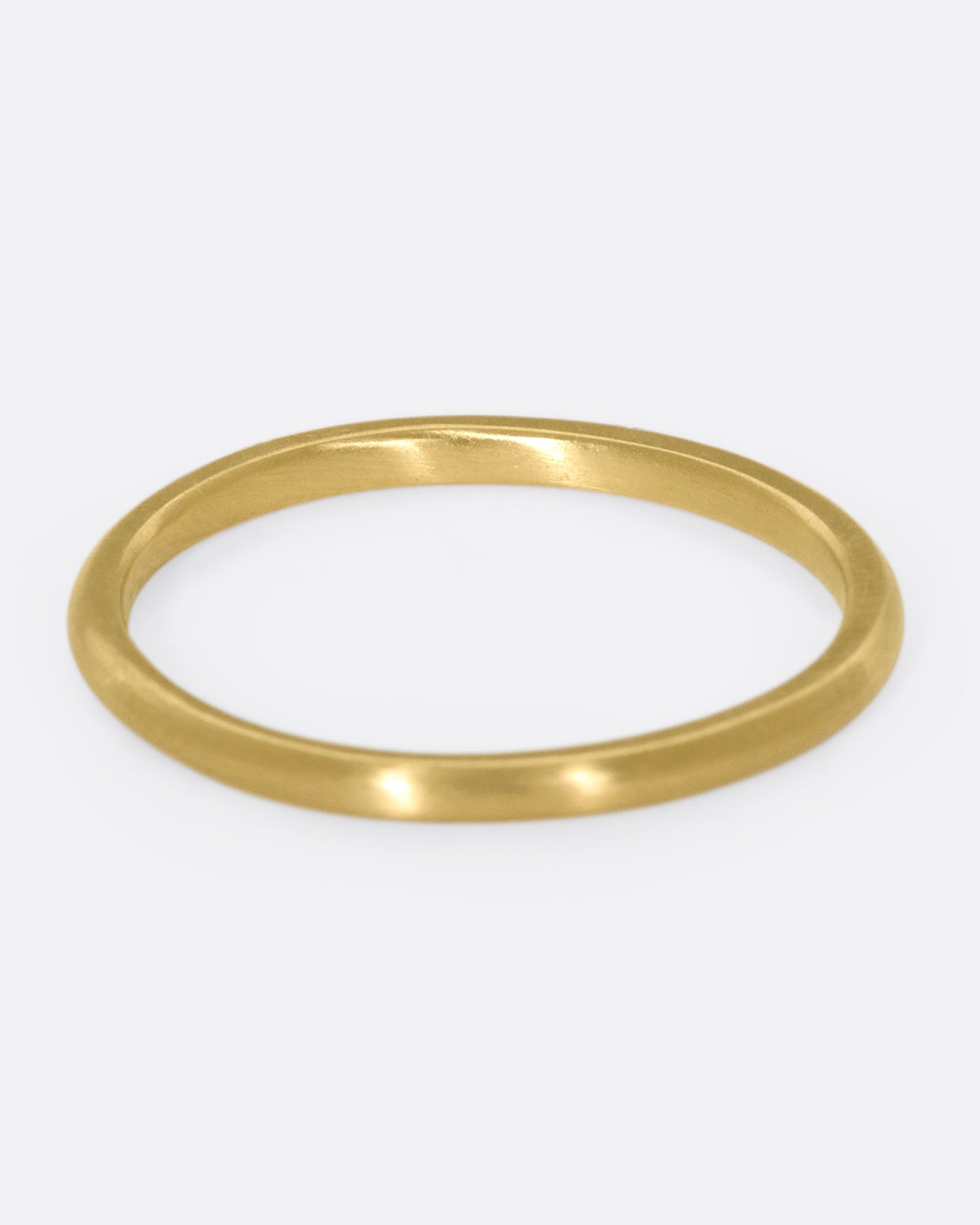 This 10k gold stacking ring features two flush-set white diamonds that sink into the soft gold band