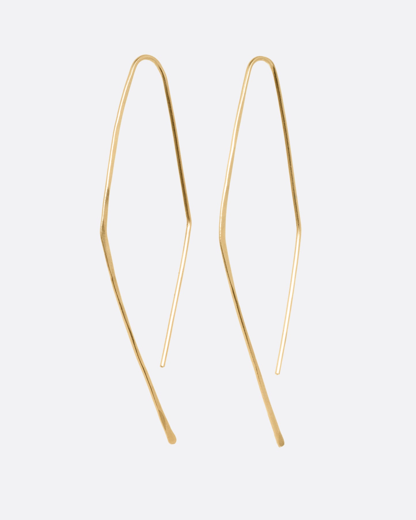 A pair of yellow gold angular hammered hook earrings. Shown from the side.