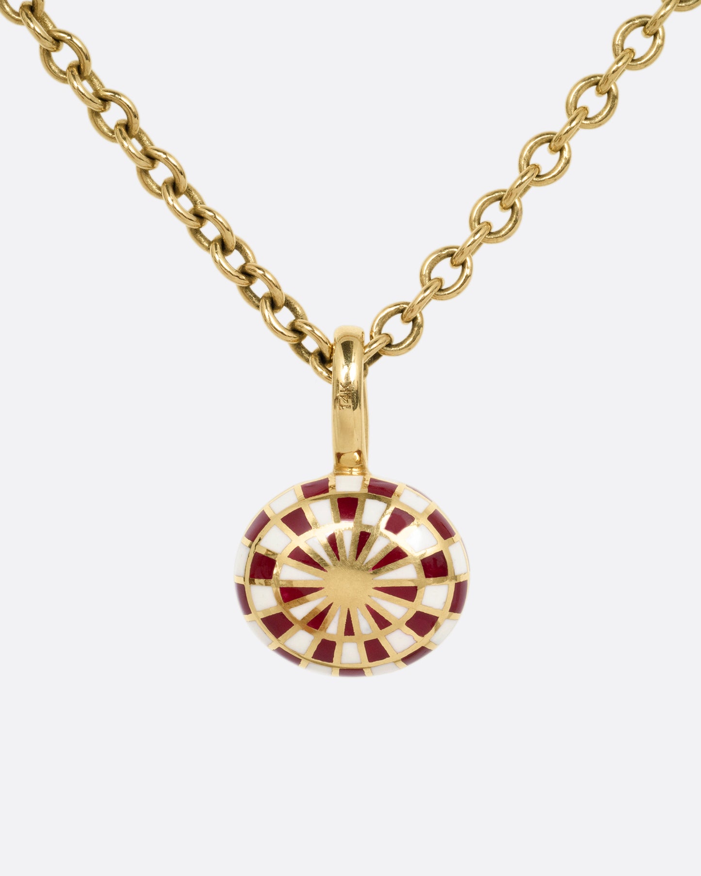 A yellow gold cable chain necklace with a red and cream enamel checkerboard pendant around a green tourmaline. The reverse side of the pendant has a checked pattern. Shown from the back.