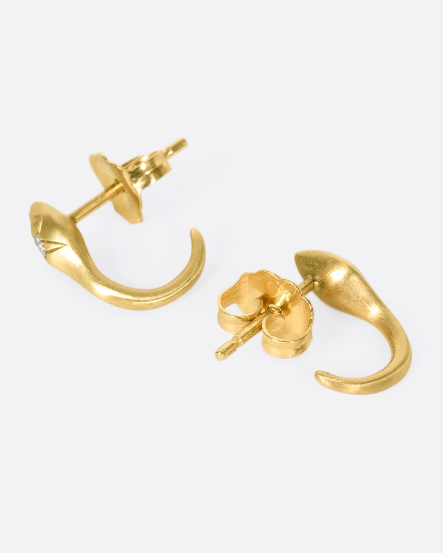 A pair of brushed 10k gold snakes that curl under your ear like tapered huggies