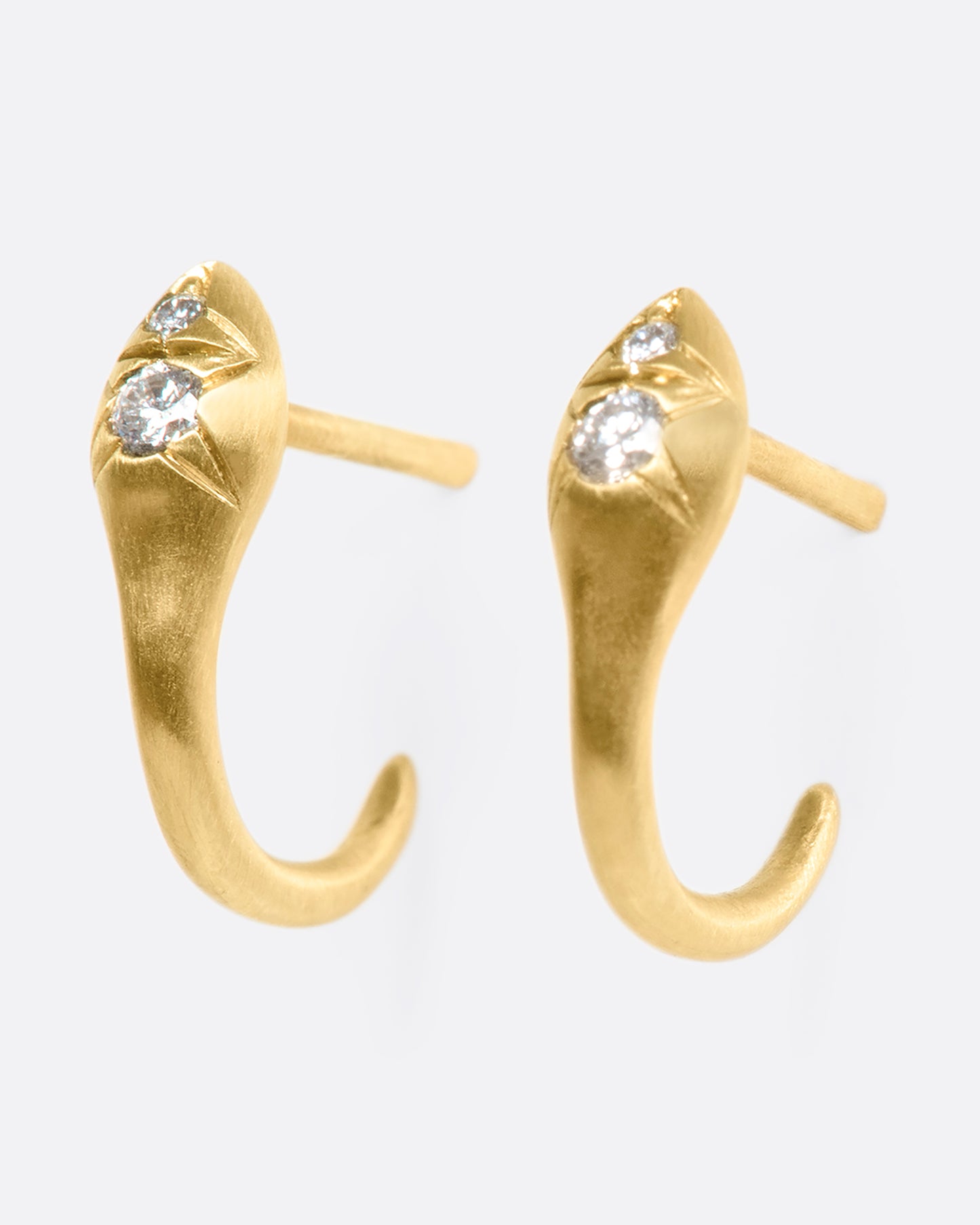 A pair of brushed 10k gold snakes that curl under your ear like tapered huggies