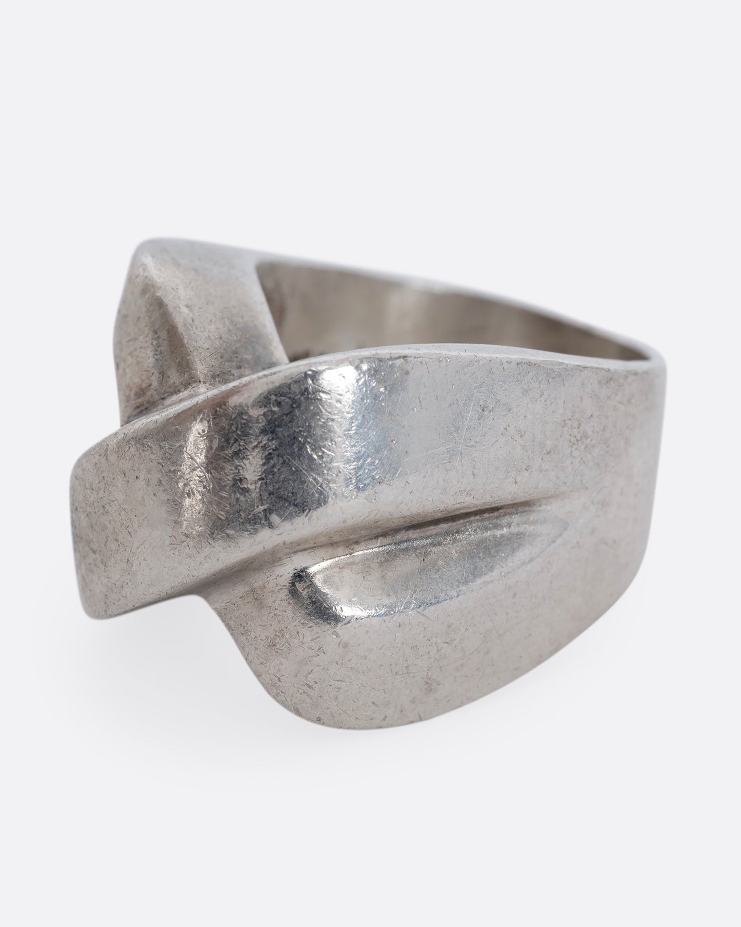 A sterling silver ring that criss crosses in the front. Shown from the side.