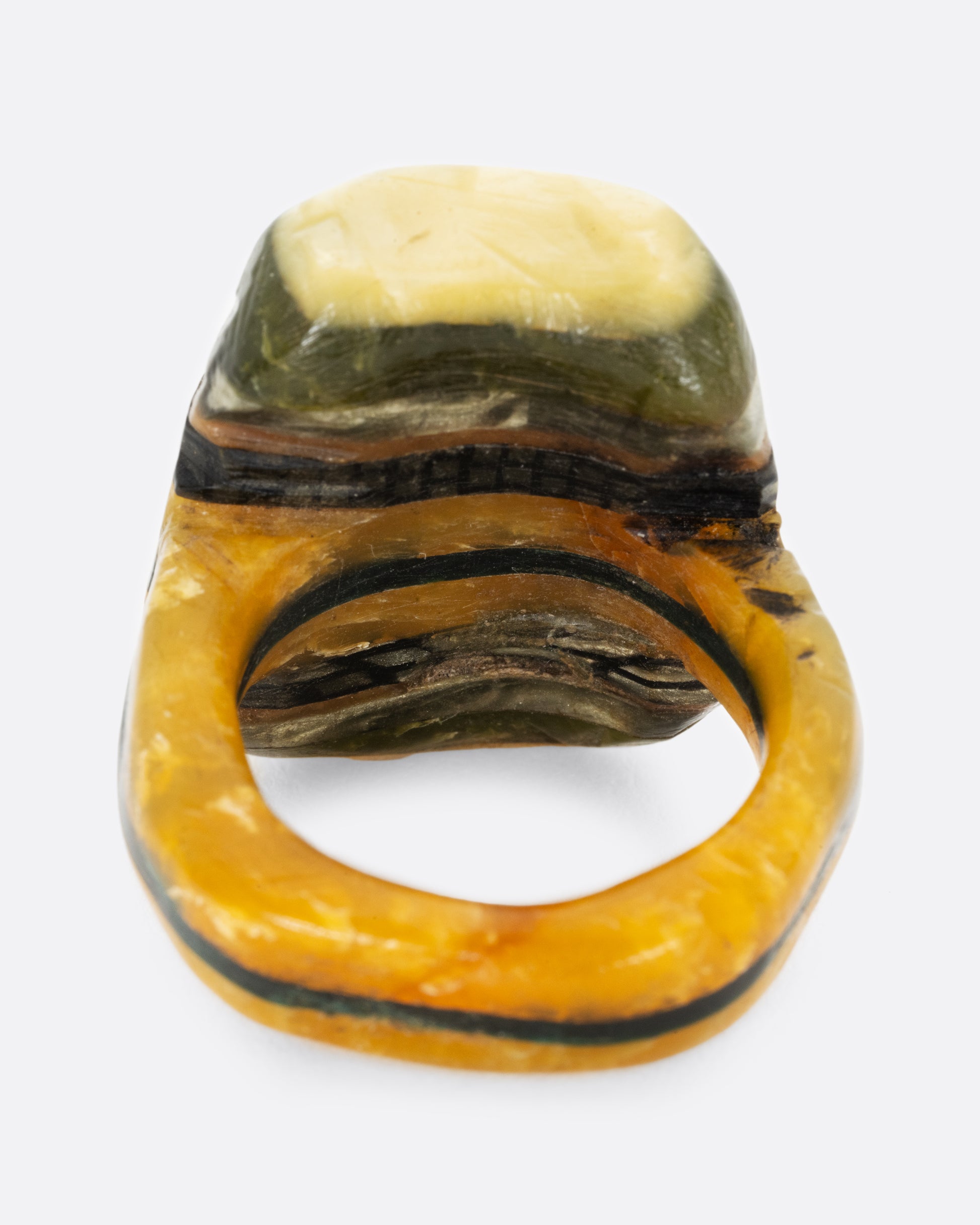 A green black and yellow composite celluloid prison art ring. Shown from the back.