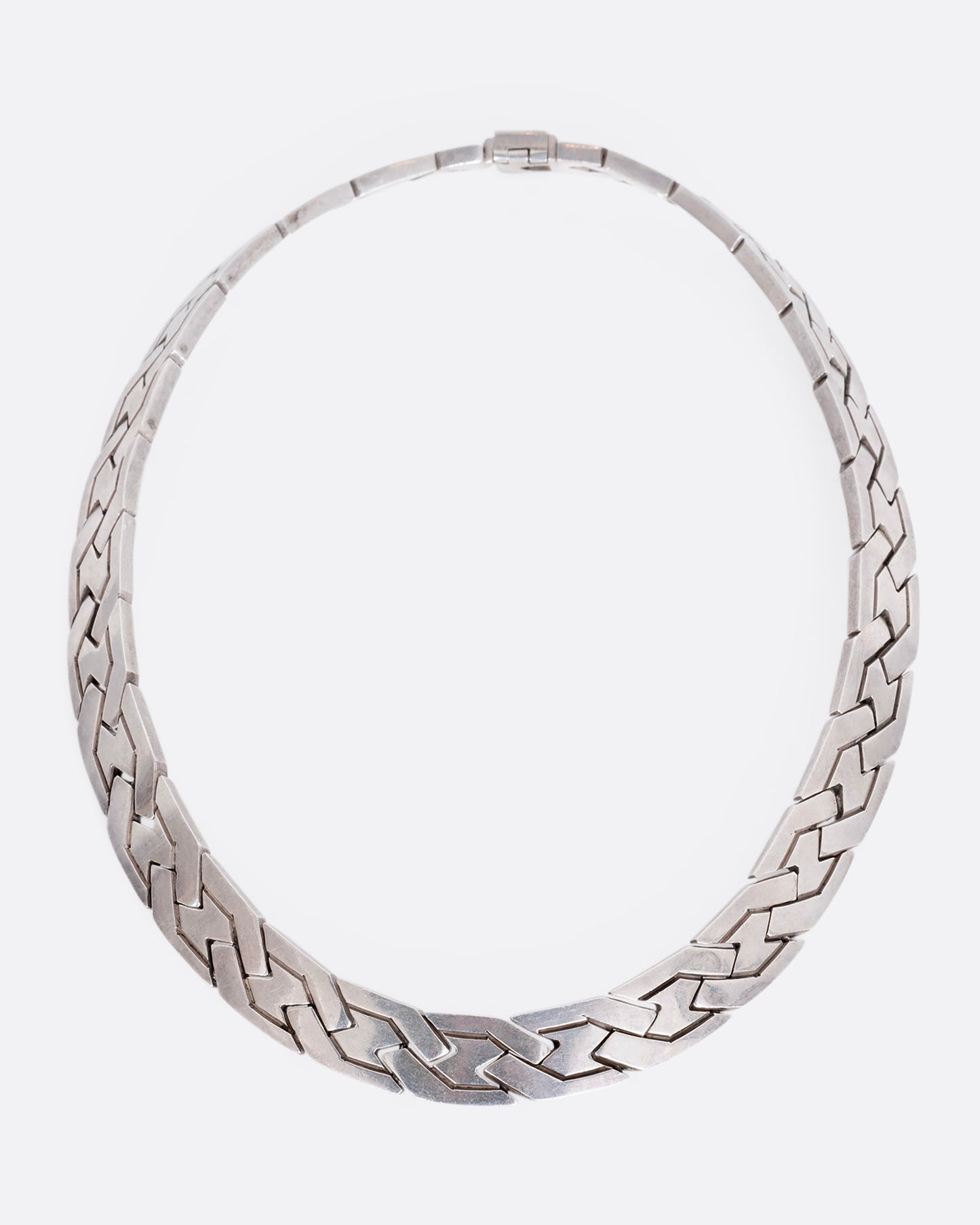 A flat woven link sterling silver necklace. View from the front.