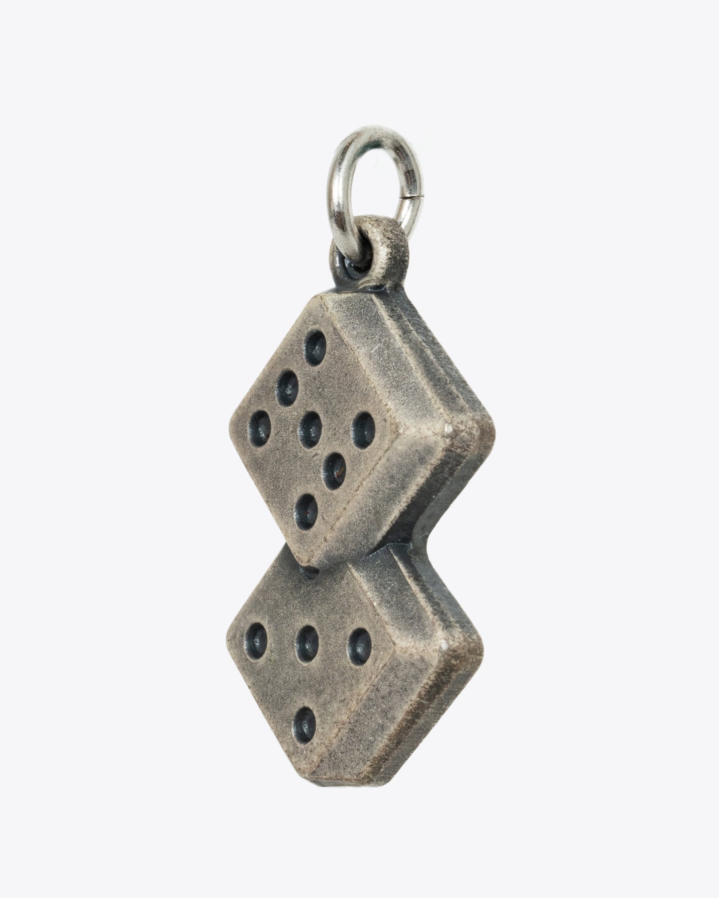 A sterling silver pendant or charm with two dice rolled to a 12. View from the side.