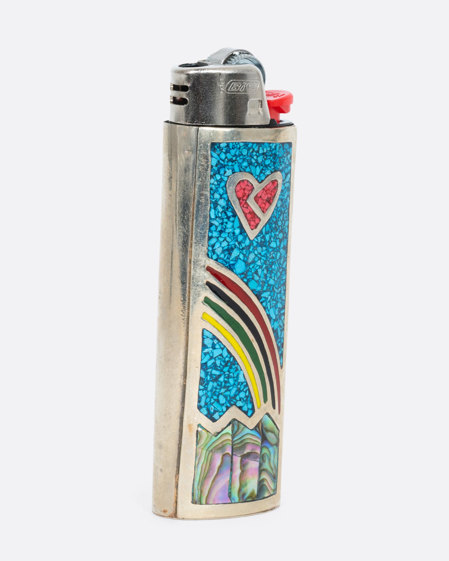 An alpaca silver lighter cover with a rainbow and heart. Shown from the side.