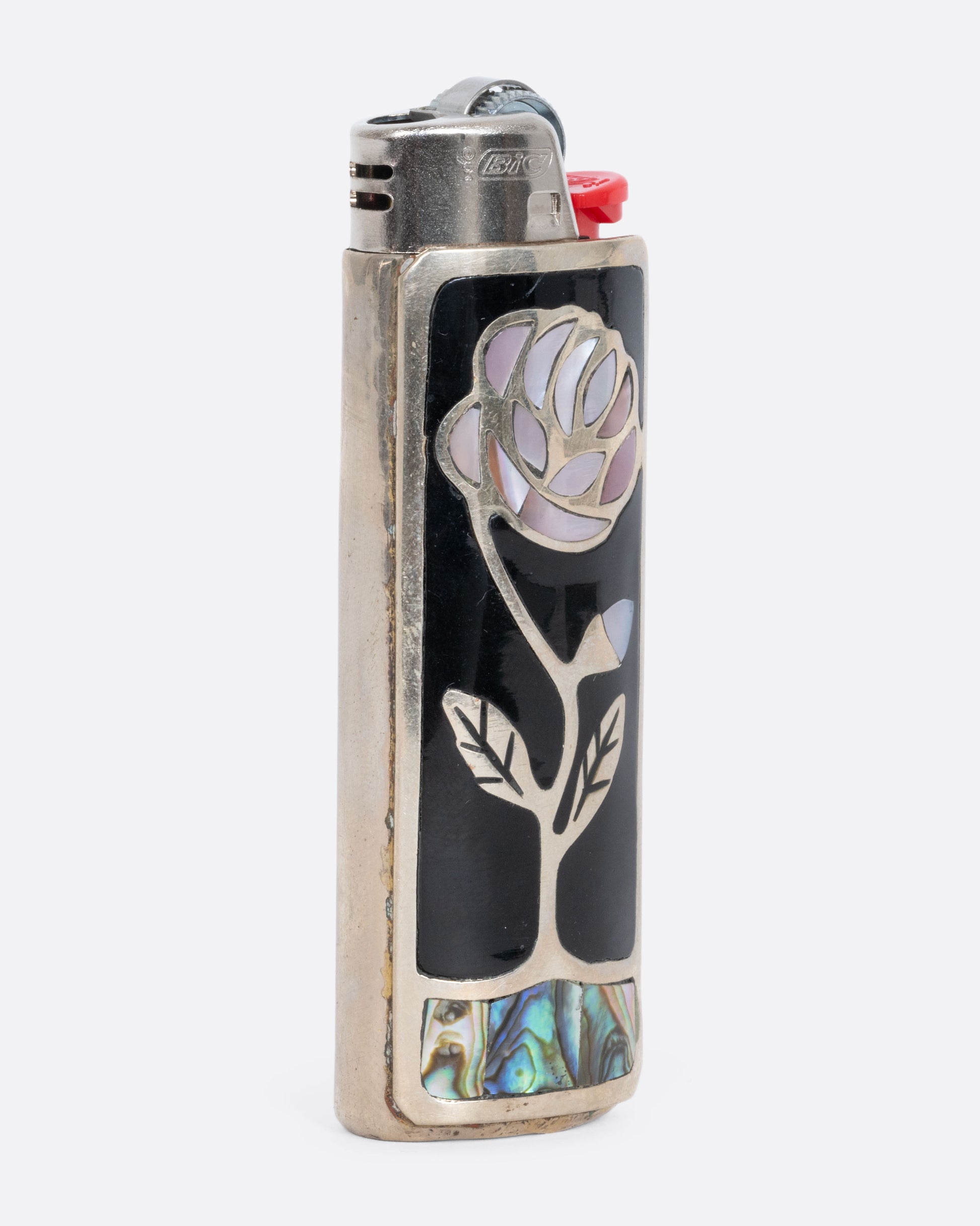 Alpaca silver lighter cover with a mother of pearl rose and abalone inlay. View from the side.