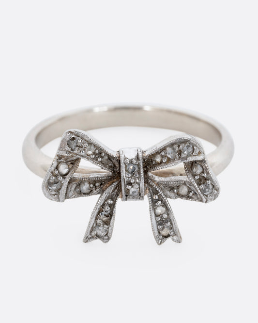 A white gold bow ring with diamonds. View from the front.