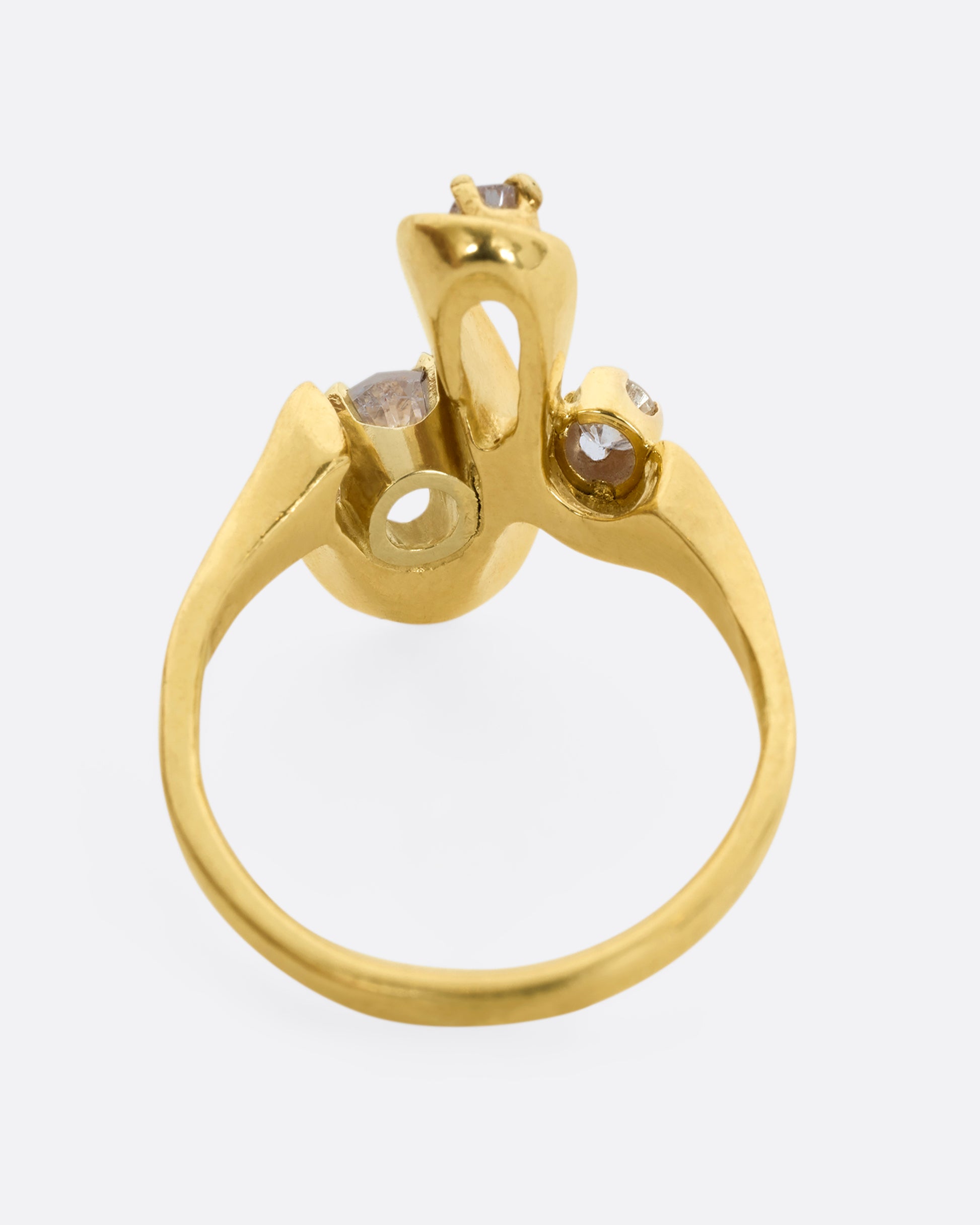 A yellow gold abstract swirl ring with three diamonds. View from the back.