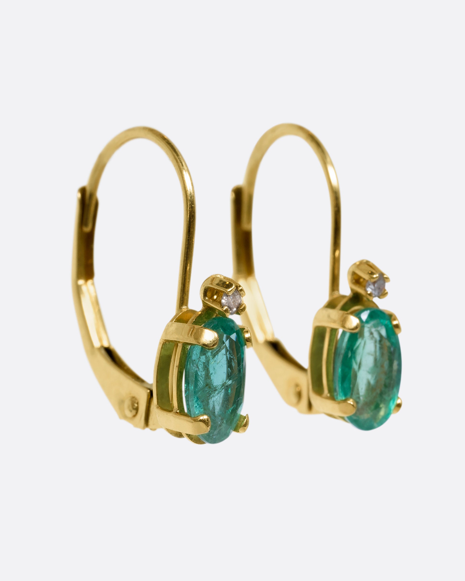 Yellow gold emerald and diamond drop earrings. View from the side.