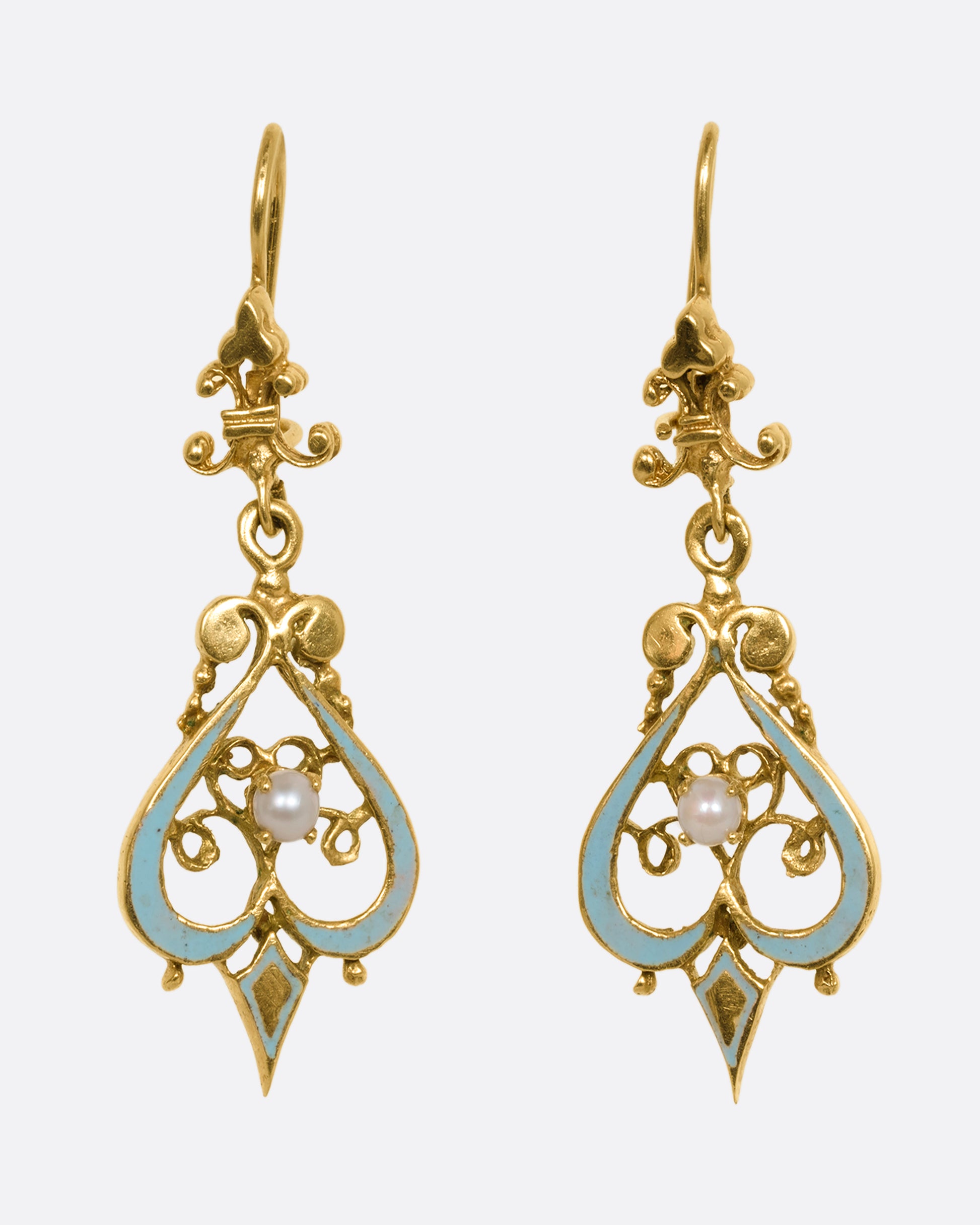 A pair of yellow gold filigree earrings with light blue enamel and pearls. Shown from the front.