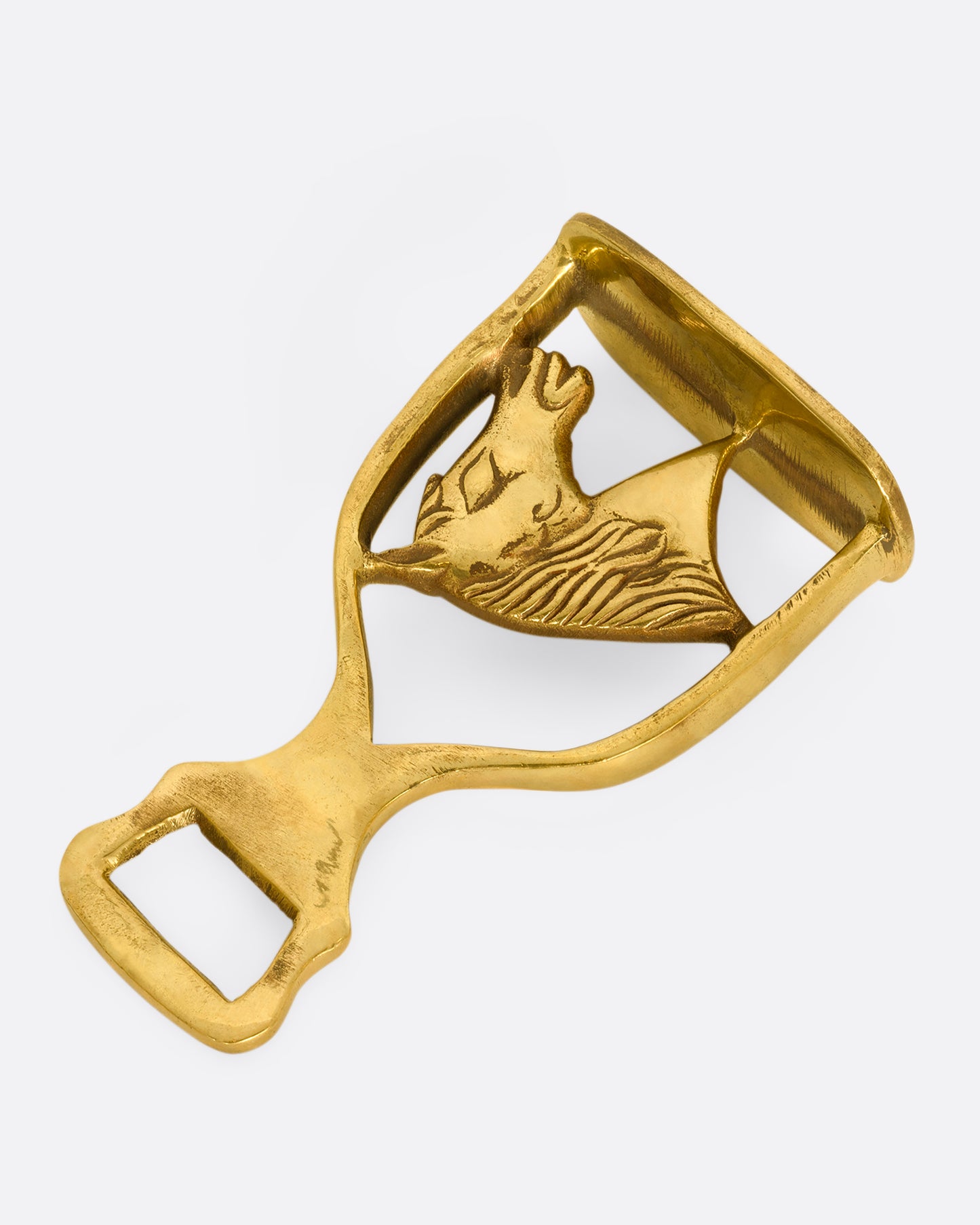 A brass horse bottle opener. Shown laying flat.