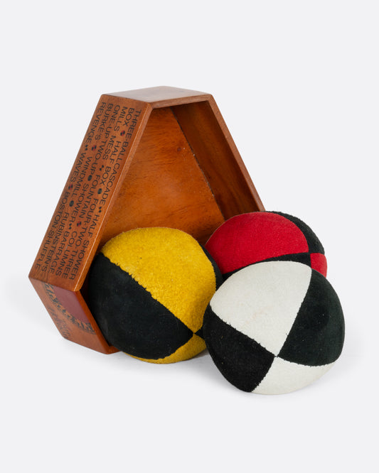 A set of three juggling balls in a wooden box. 