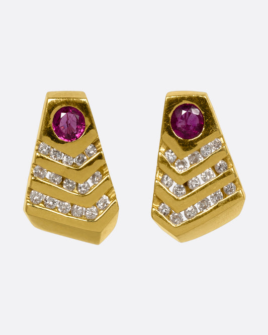 A pair of geometric yellow gold earrings with rubies and diamonds. View from the front.