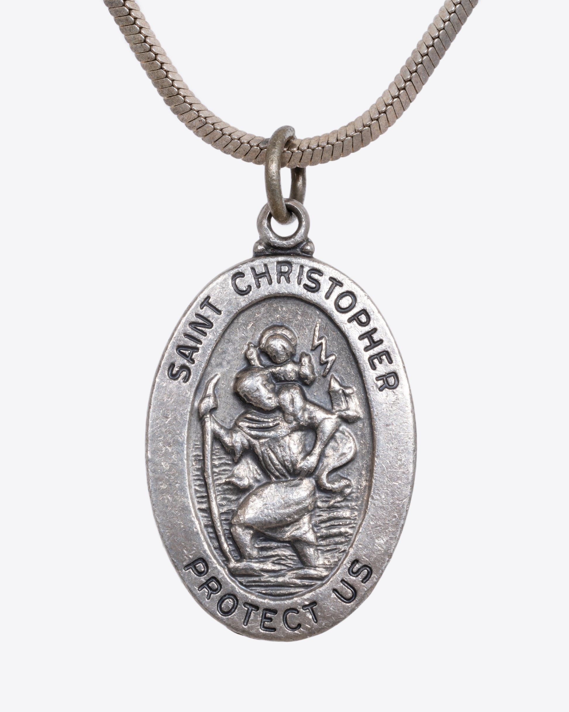 A sterling silver St. Christopher pendant hanging from a snake chain. View close up from the front.