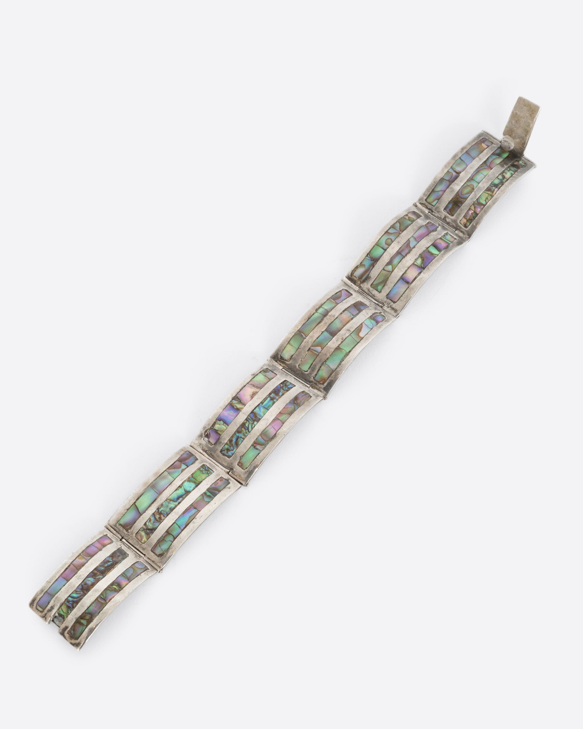 A sterling silver bracelet with rectangular links containing three abalone stations on each. View laying flat.