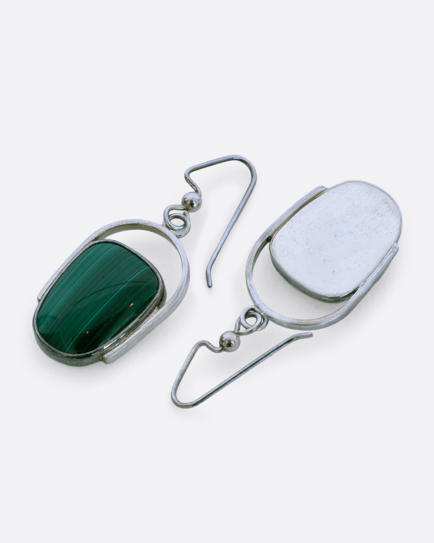 Sterling silver curved drop earrings with malachite. View laying flat.