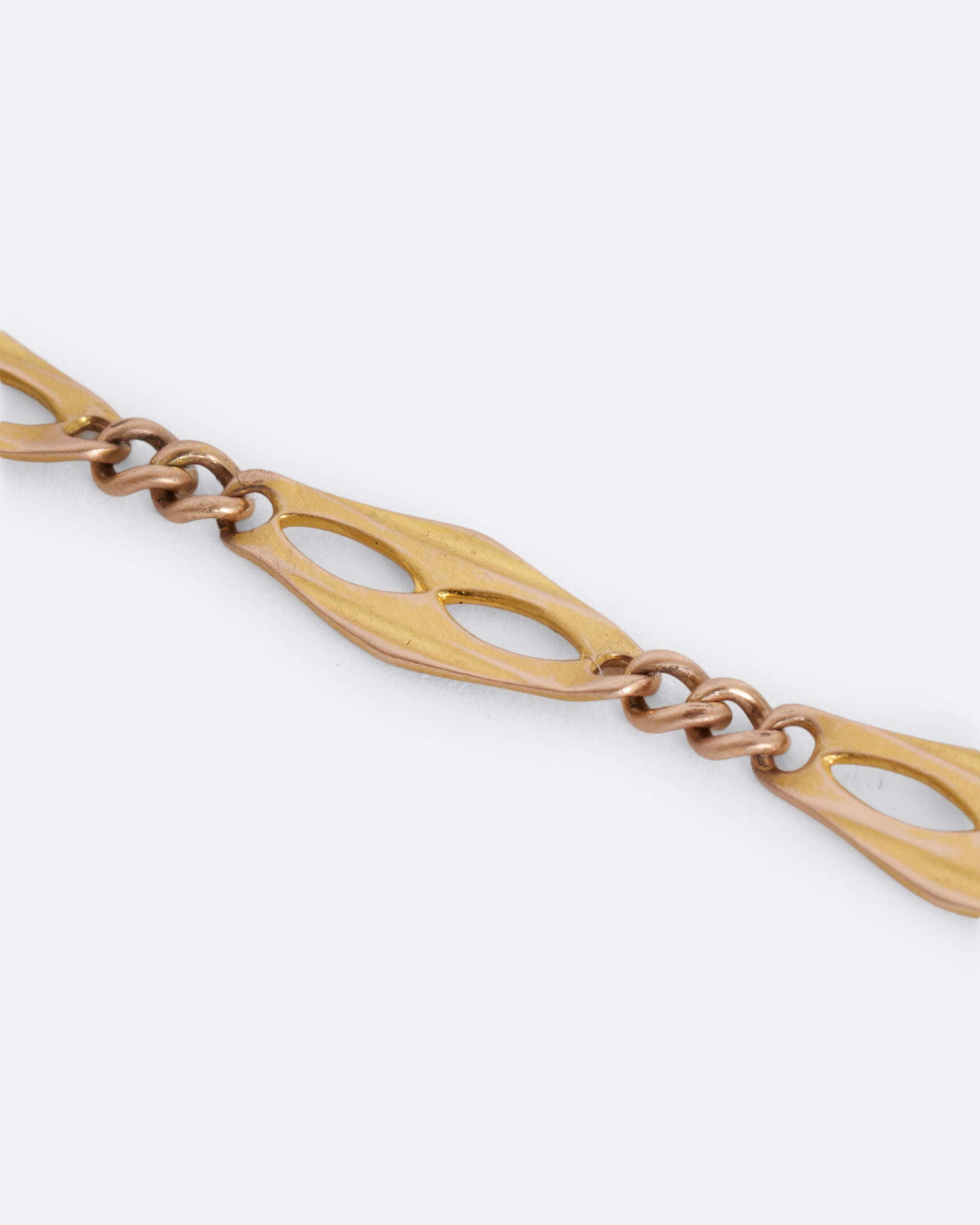 A yellow gold watch chain with fancy links. View up close of the links.