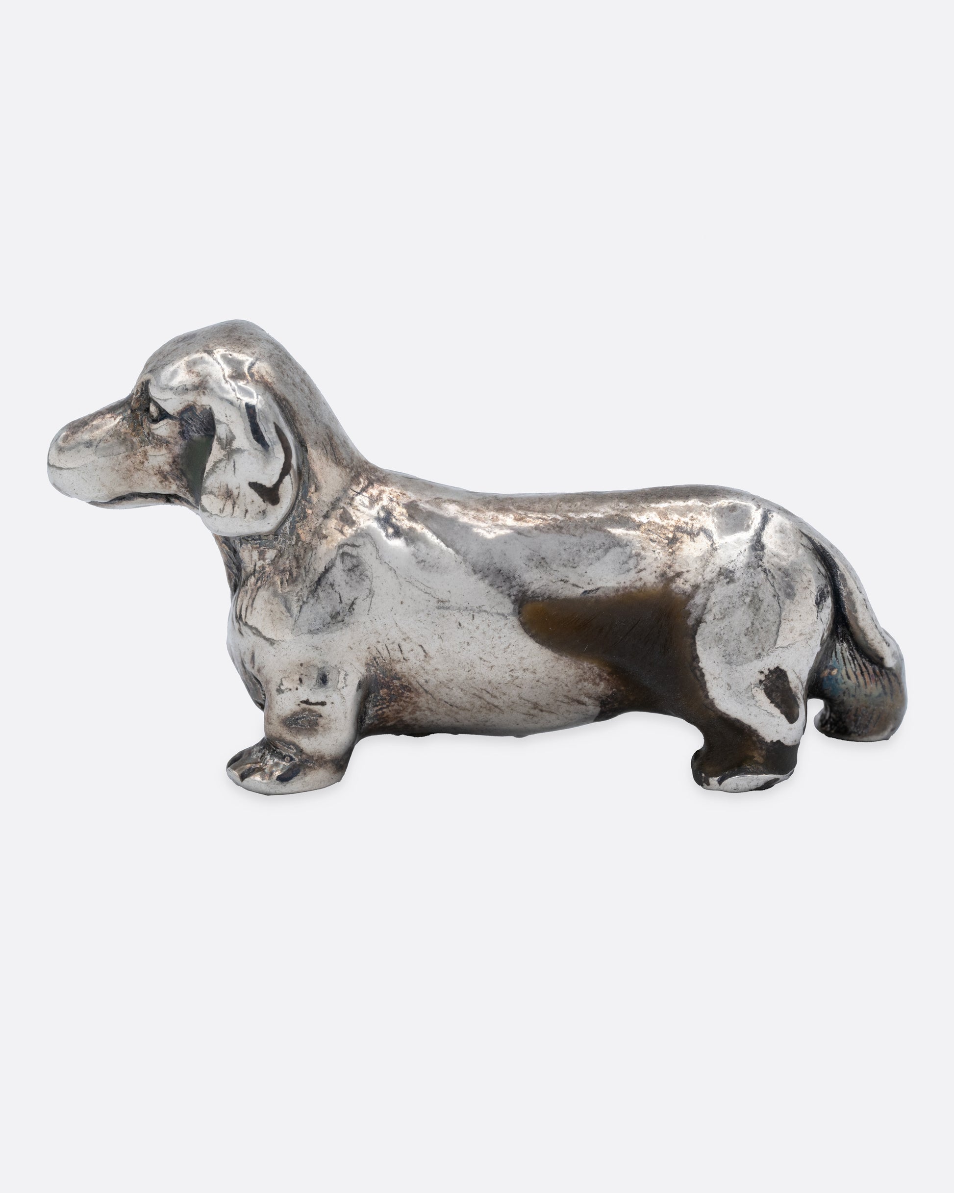 A silver dachshund figurine, shown from the side.