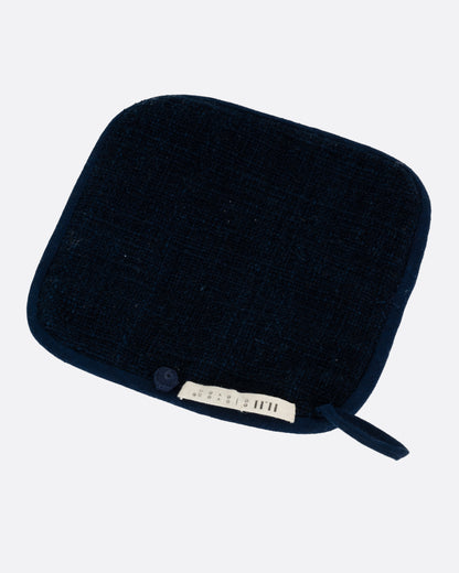 Quilted indigo pot holder, back of the pot holder with the label