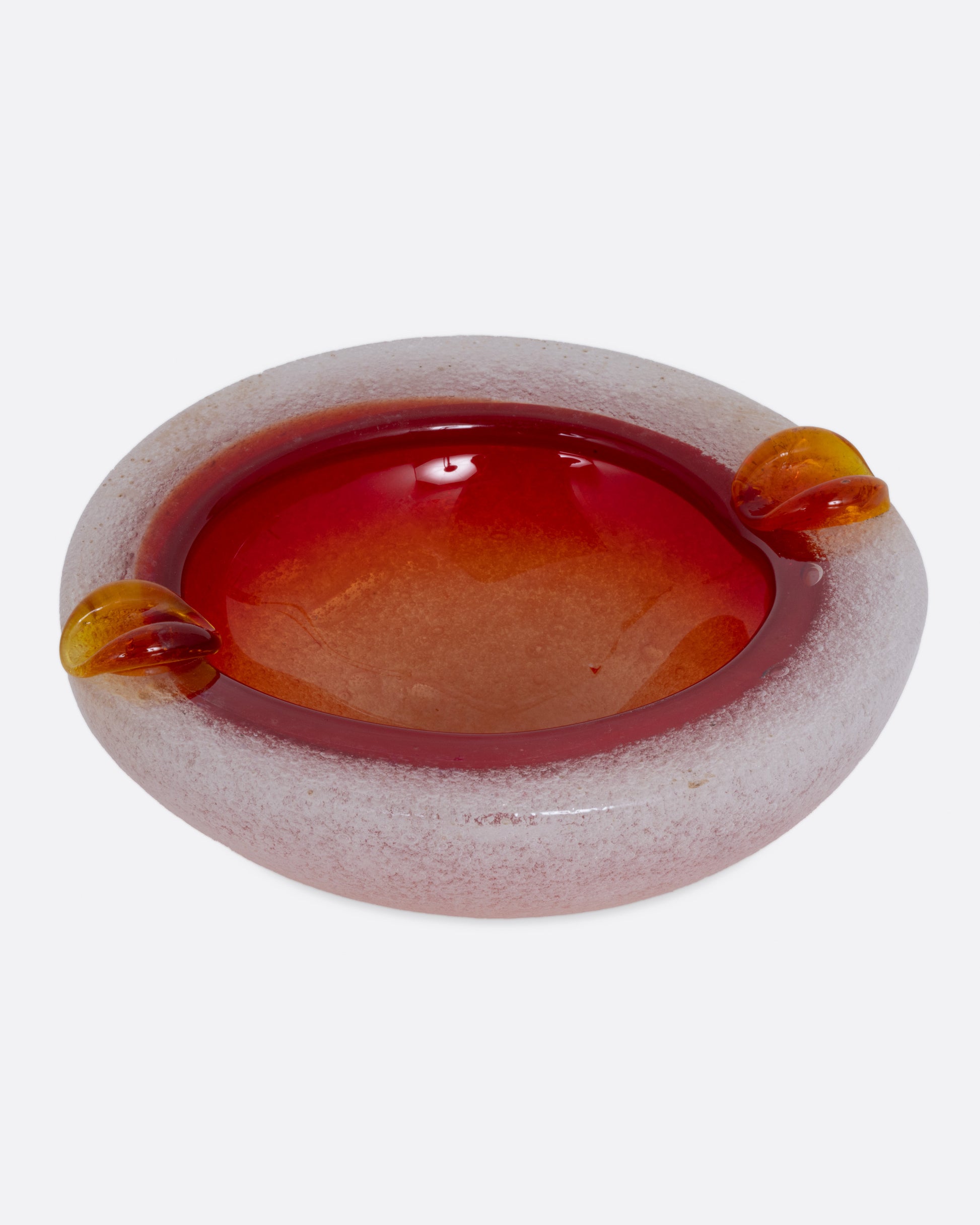 An orange and white blown glass ashtray, shown from the front.