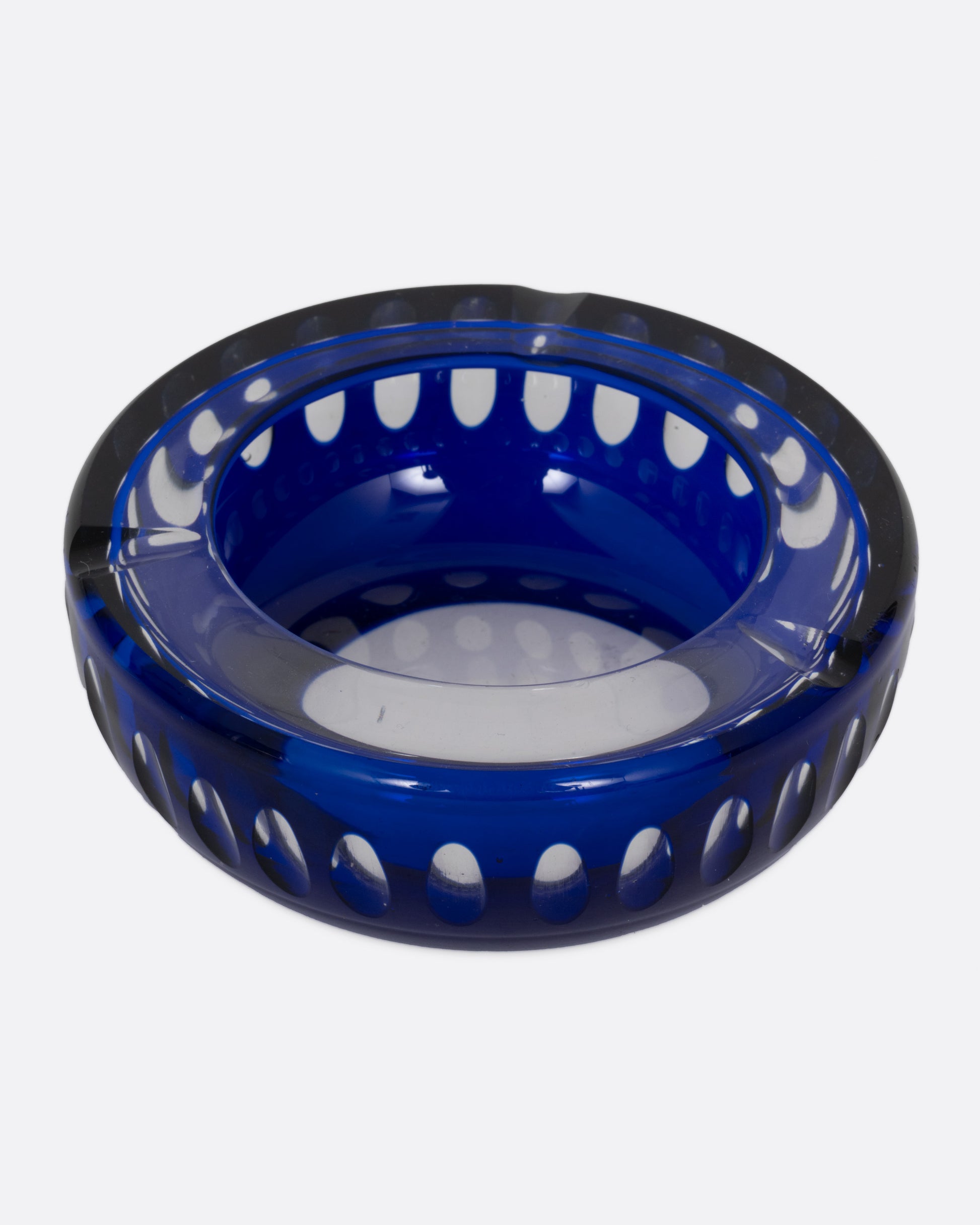 A blue glass ashtray with a bubbly design, shown from the top.