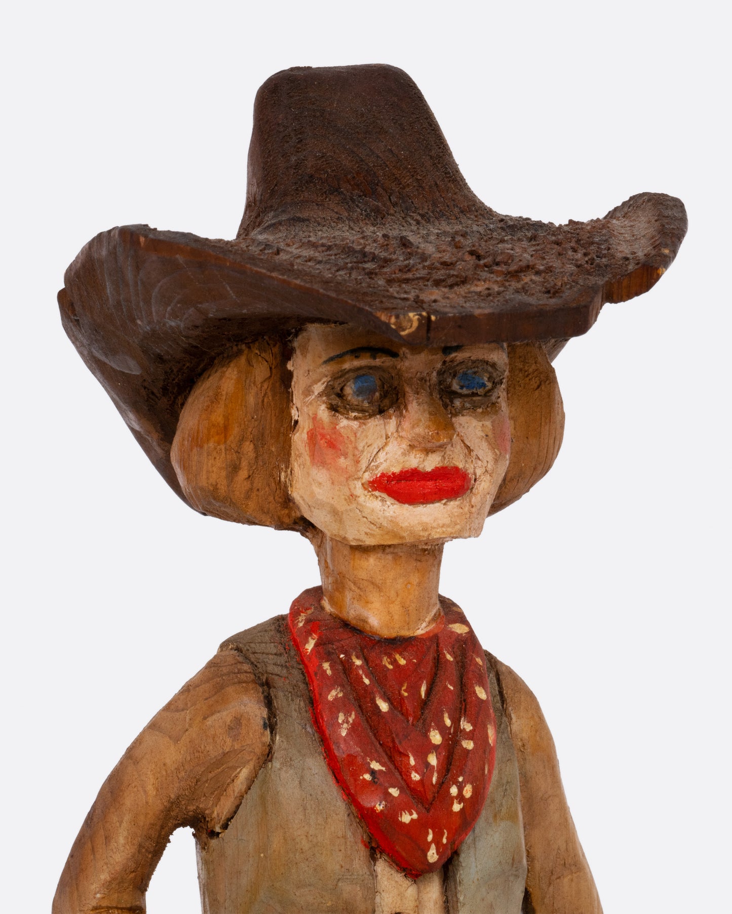  A close up of a wooden hand carved and painted folk art cowgirl holding a bucket. 