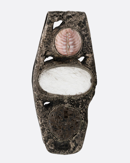 A textural silver money clip with a  pebble, quartz, and seashell set in the front, shown from the front.