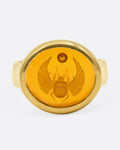 A yellow gold signet ring with a citrine with a hand carved scarab, shown from the front.